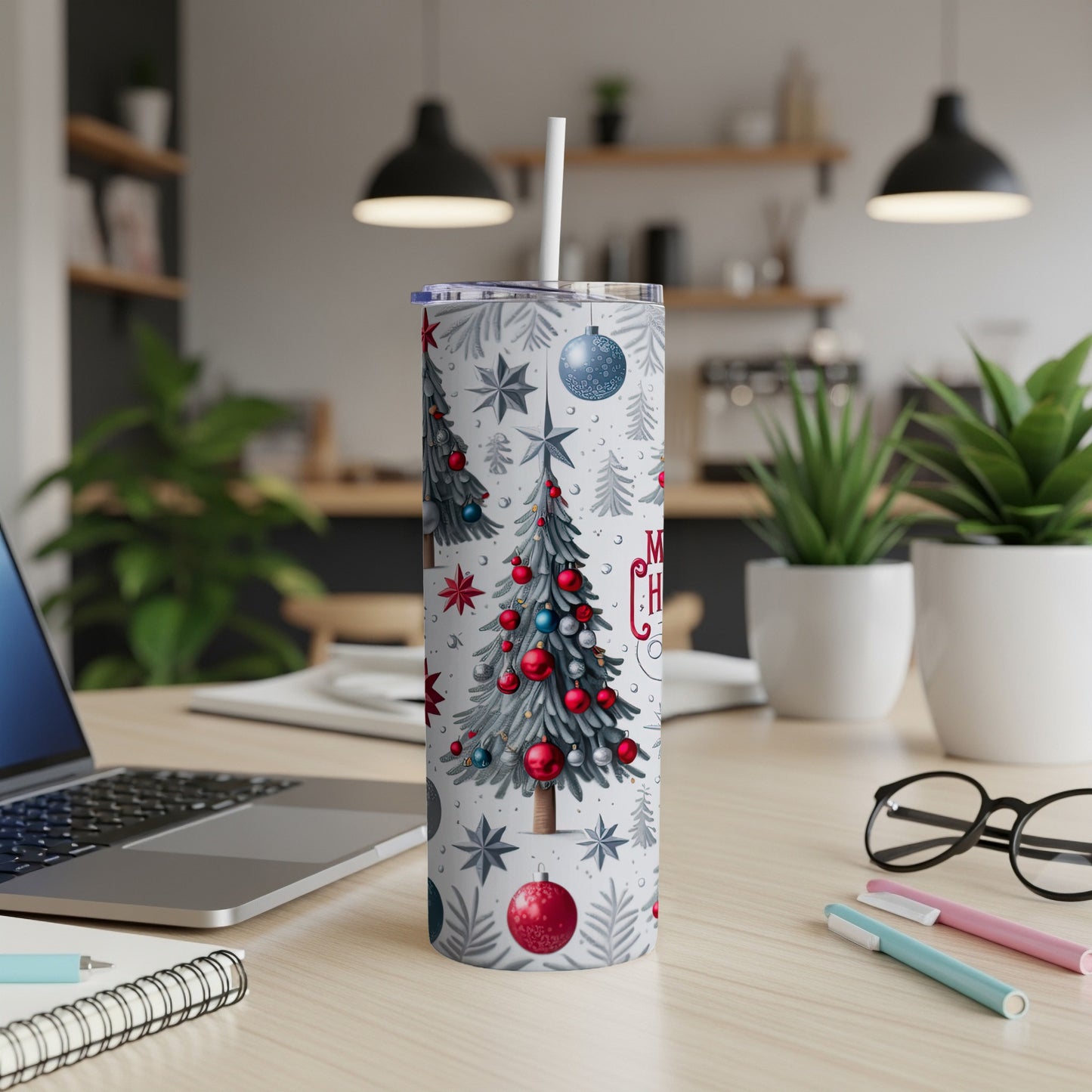 Christmas tree tumbler with straw on a desk.