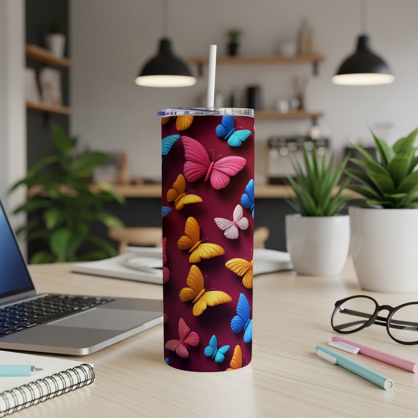 Maroon tumbler with colorful butterfly pattern, lid, and straw.