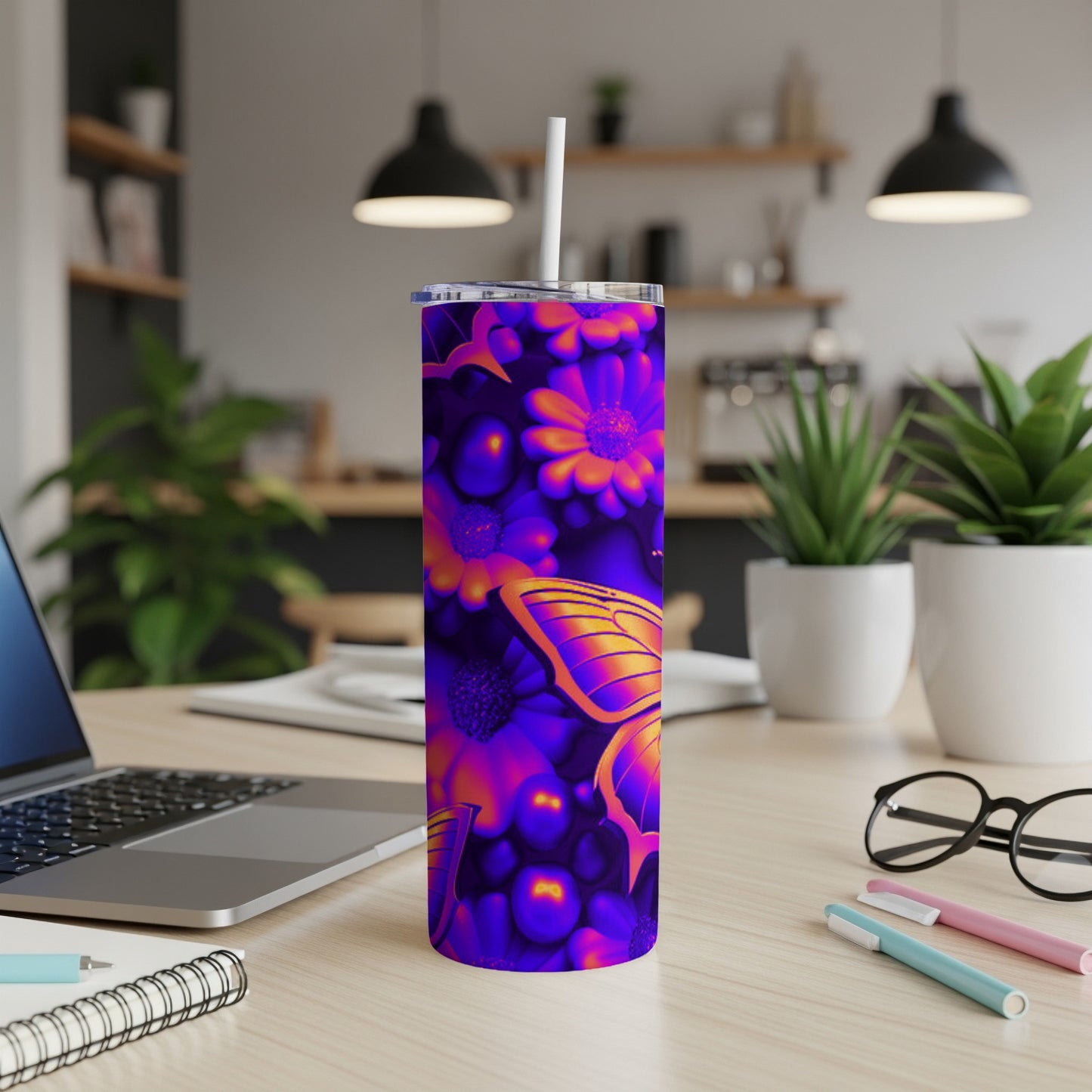Purple and orange floral pattern tumbler with butterfly, on a desk.