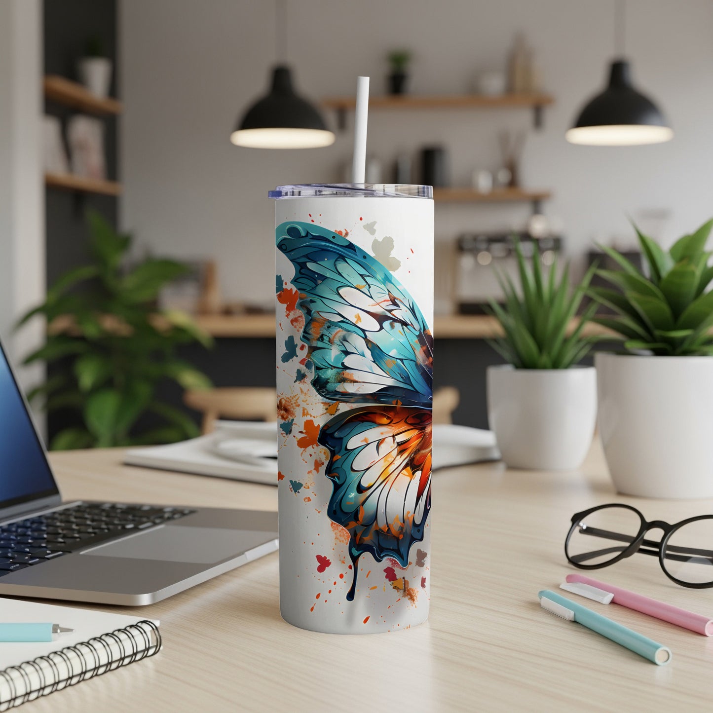 White tumbler with colorful butterfly wing design and straw.