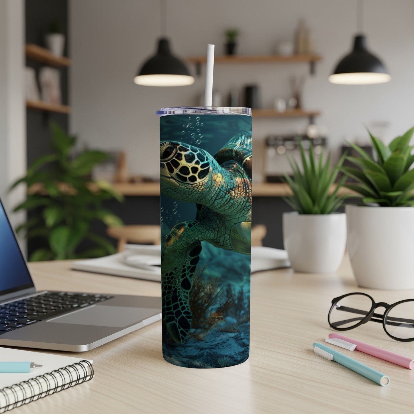 Sea turtle swimming underwater, with a white straw in a tumbler on a desk.