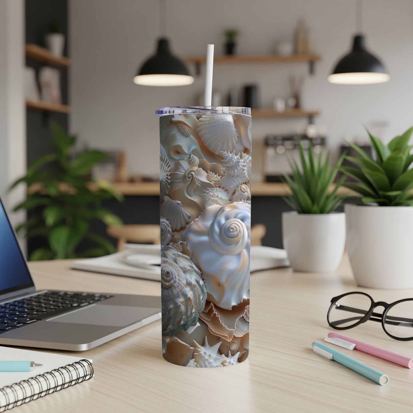 Tall tumbler with detailed seashell pattern, standing on a desk.