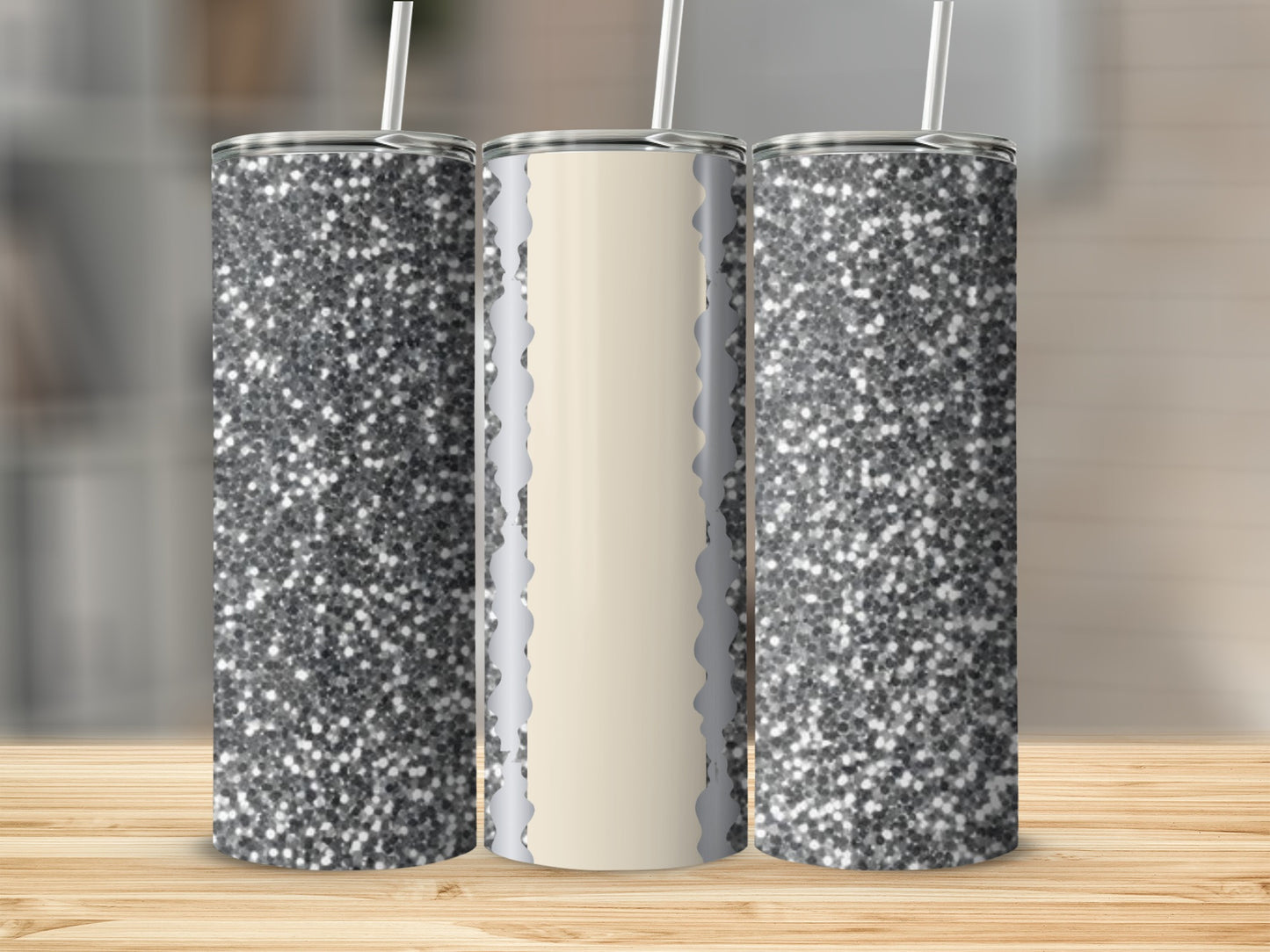 Three glittery tumblers with straws on a wooden surface.