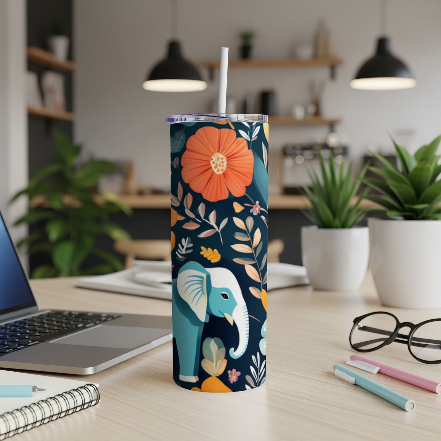 Blue elephant and floral design on a white insulated tumbler with straw.