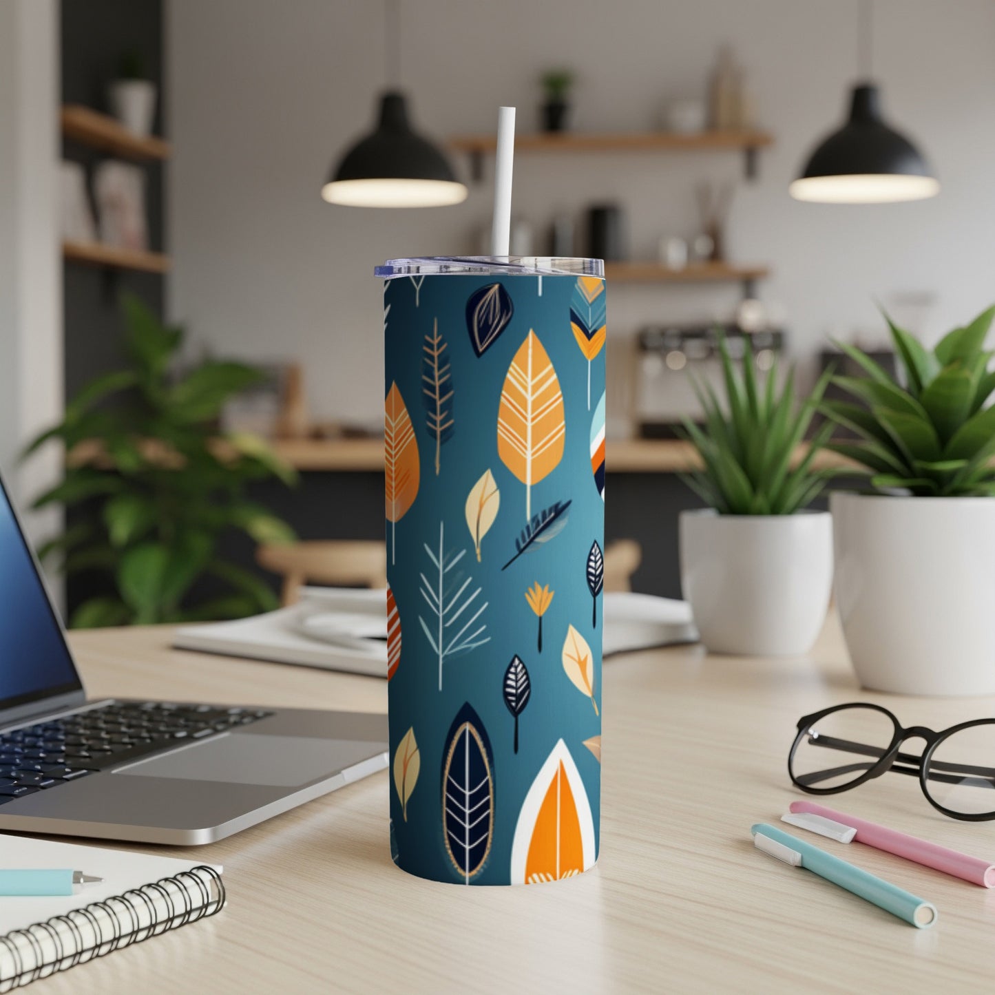 Dark teal tumbler with a repeating leaf pattern in orange, white, and blue.