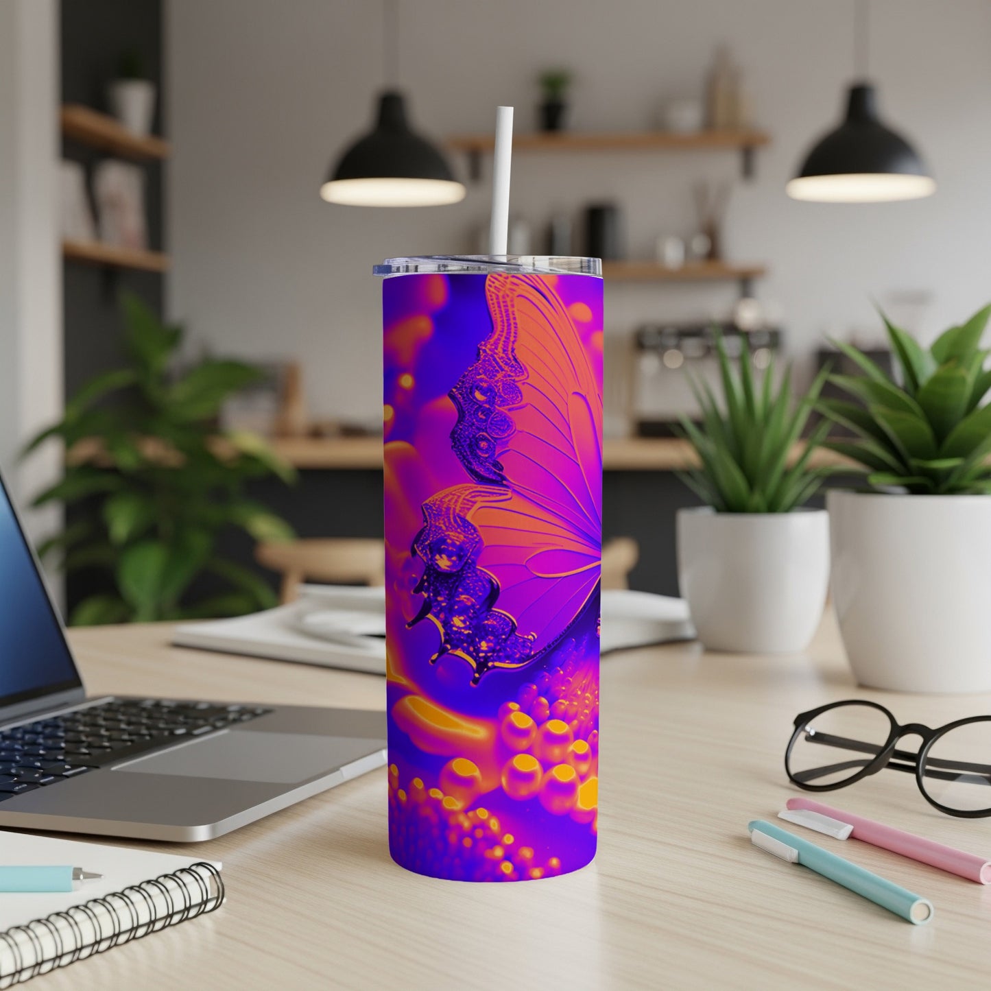 Purple and orange butterfly design on a skinny tumbler with a straw.