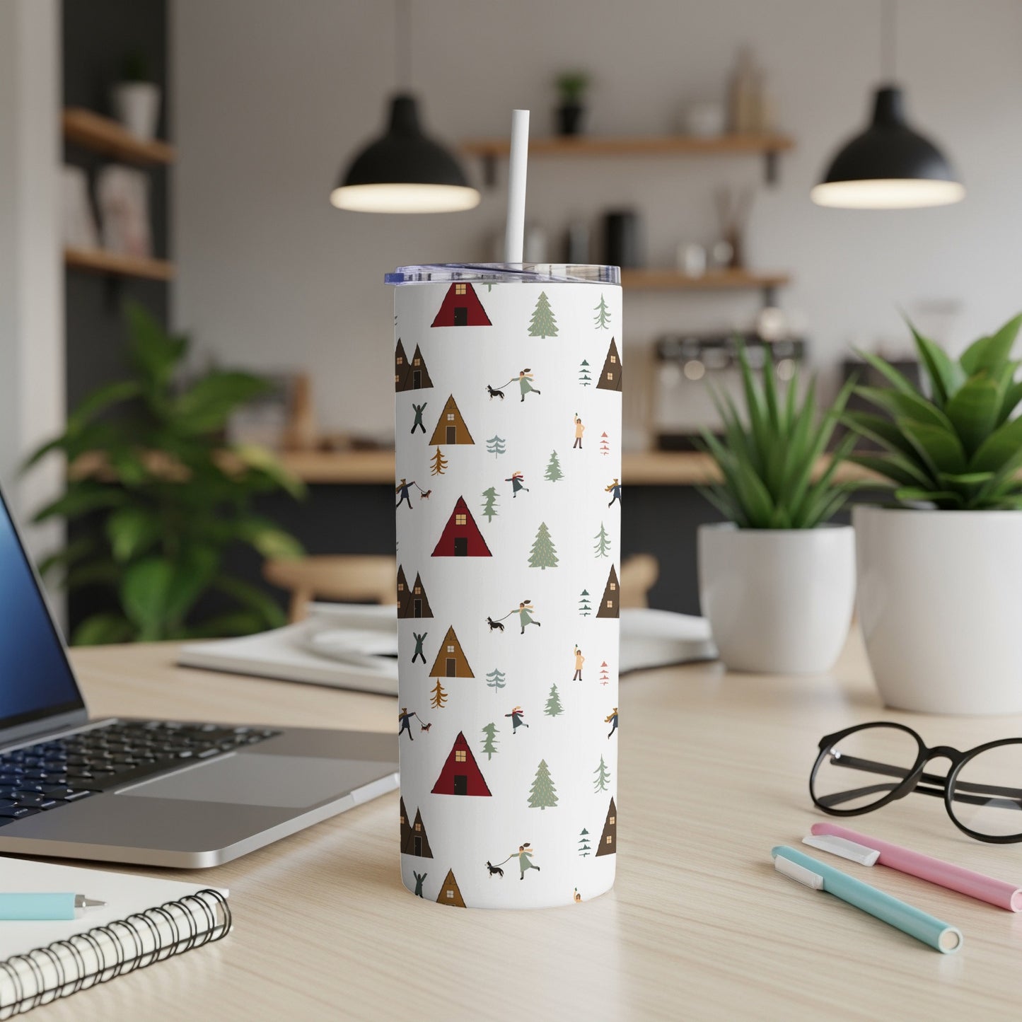 White tumbler with repeating pattern of tents, trees, and people.