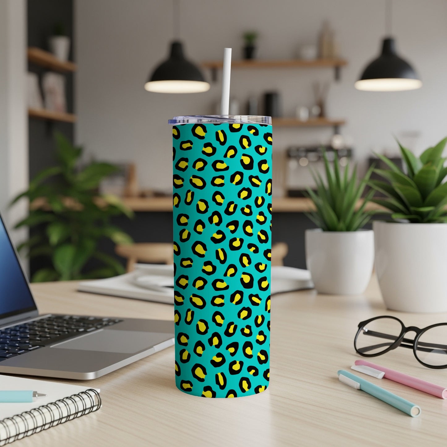 Teal tumbler with yellow and black leopard print and white straw.