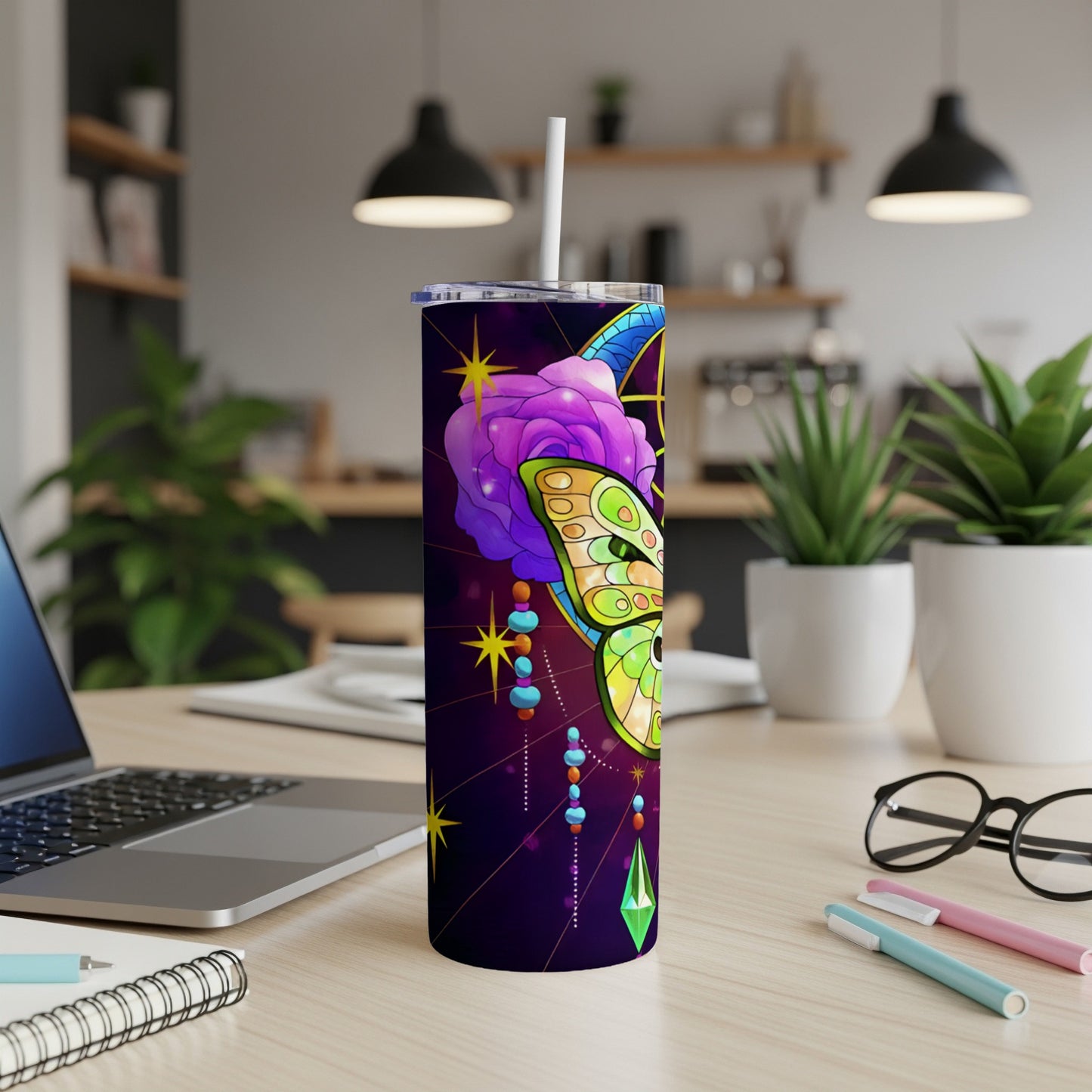 Purple tumbler with iridescent butterfly and celestial design on desk.