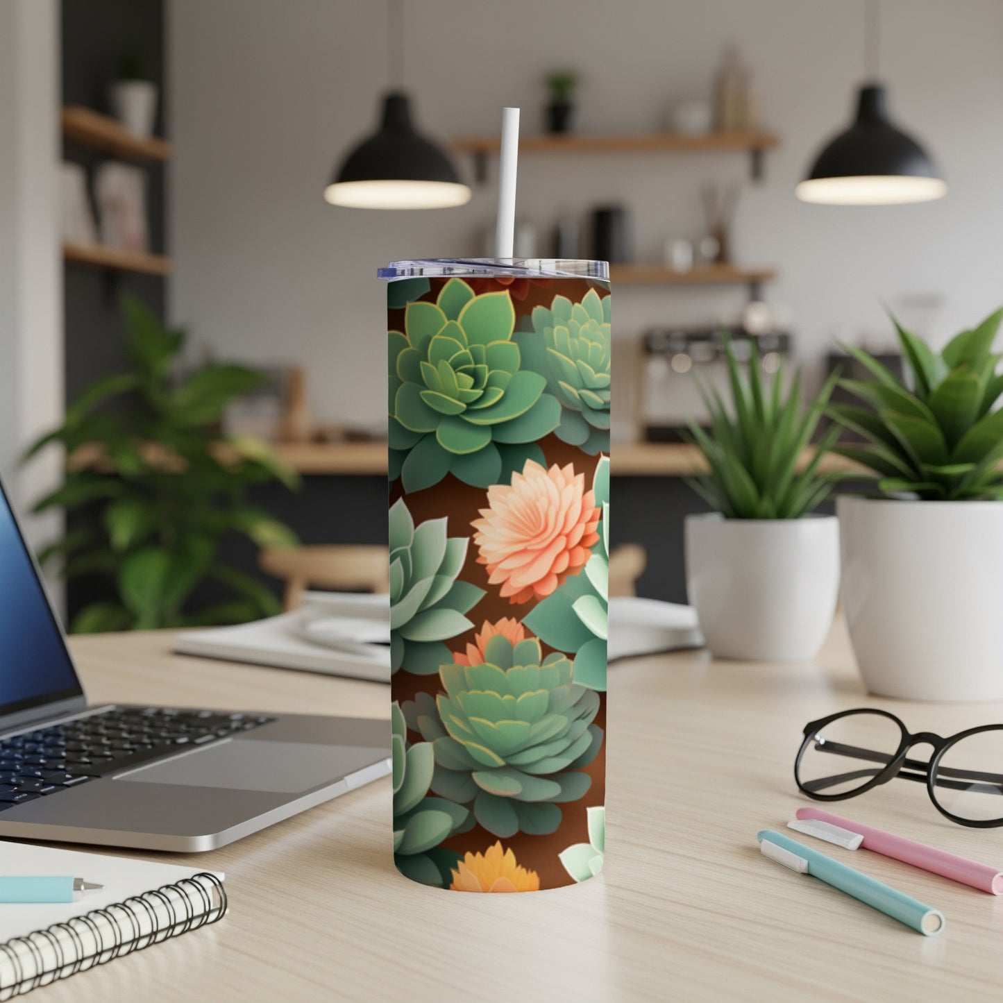 Brown tumbler with repeating succulent floral pattern, set on a desk.