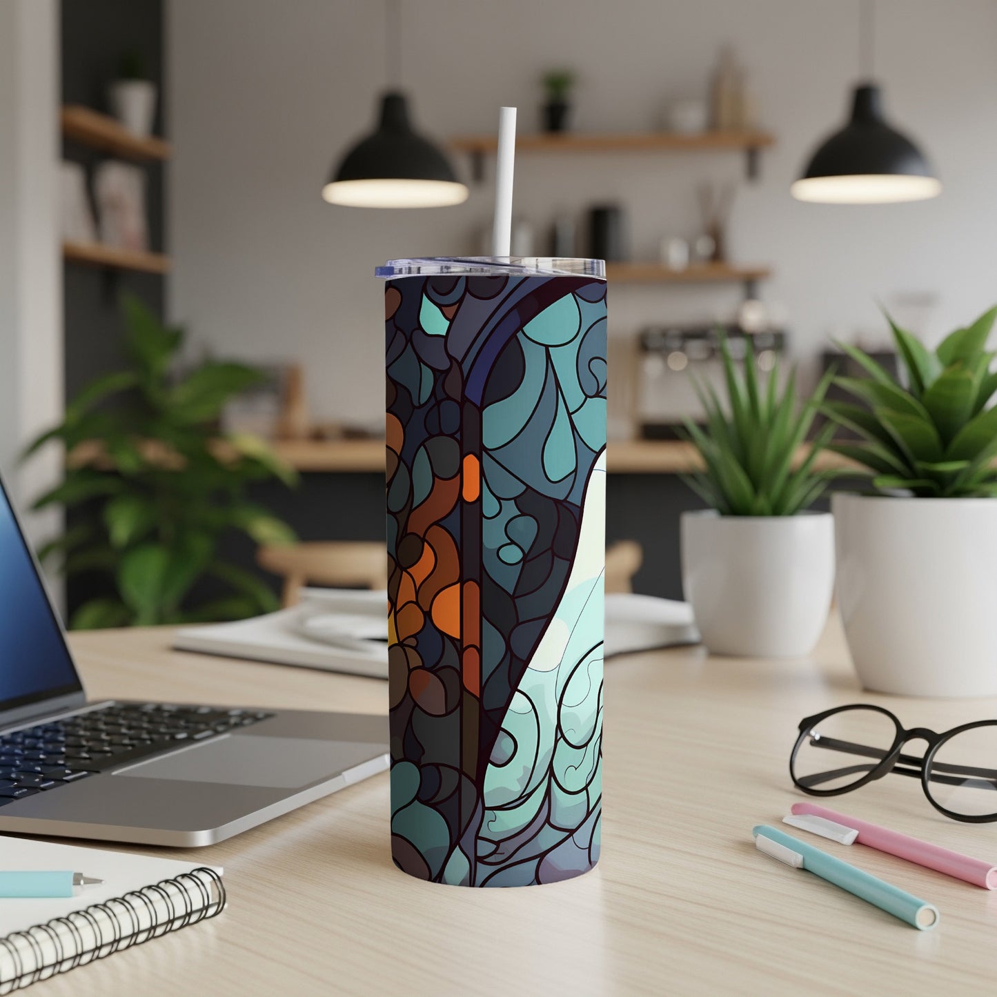 Tall tumbler with abstract blue and orange design, on a desk with laptop.