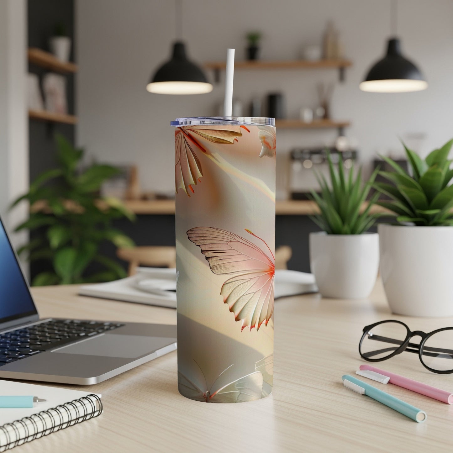 Tall tumbler with a delicate butterfly design on a desk.