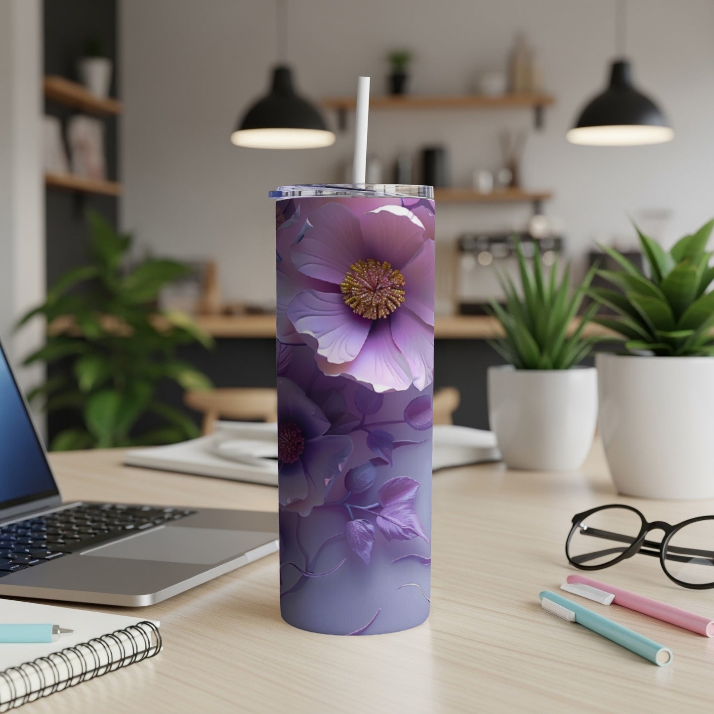Purple floral skinny tumbler with straw on a desk.