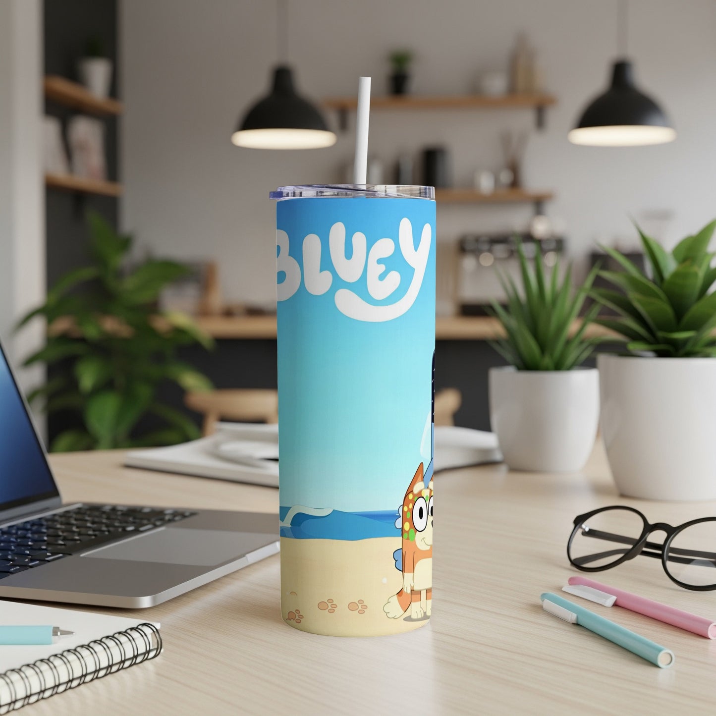 Bluey character tumbler with straw on a desk with a laptop and pens.