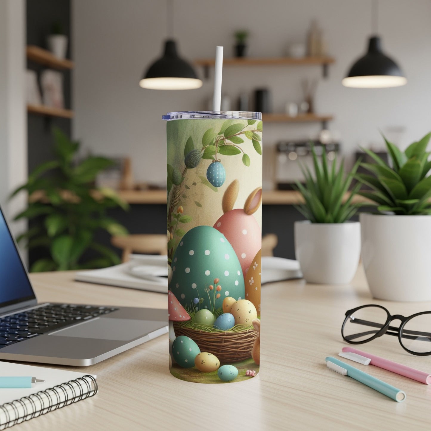 Easter tumbler with decorated eggs and bunny ears on a desk.