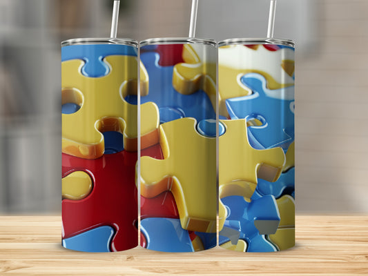 Three colorful puzzle piece tumblers with straws on a wooden surface.