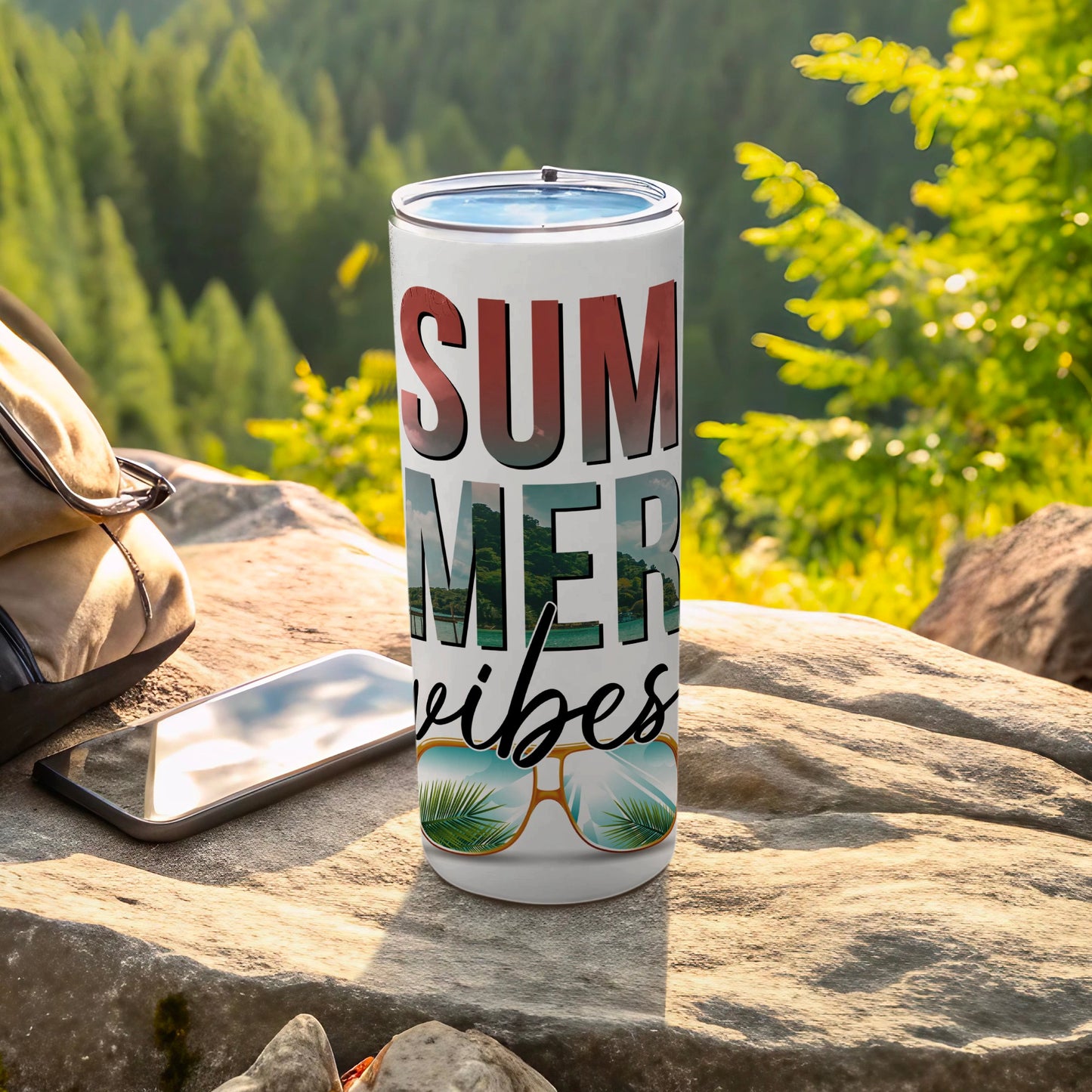 Tumbler with "SUMMER VIBES" and sunglasses design outdoors.