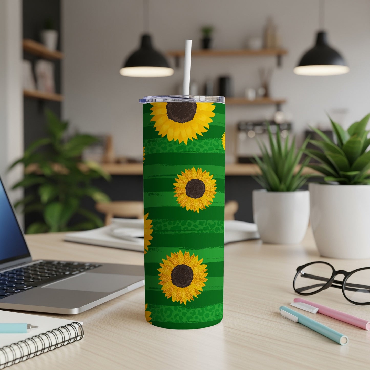 Green striped tumbler with sunflowers and leopard print accents on a desk.