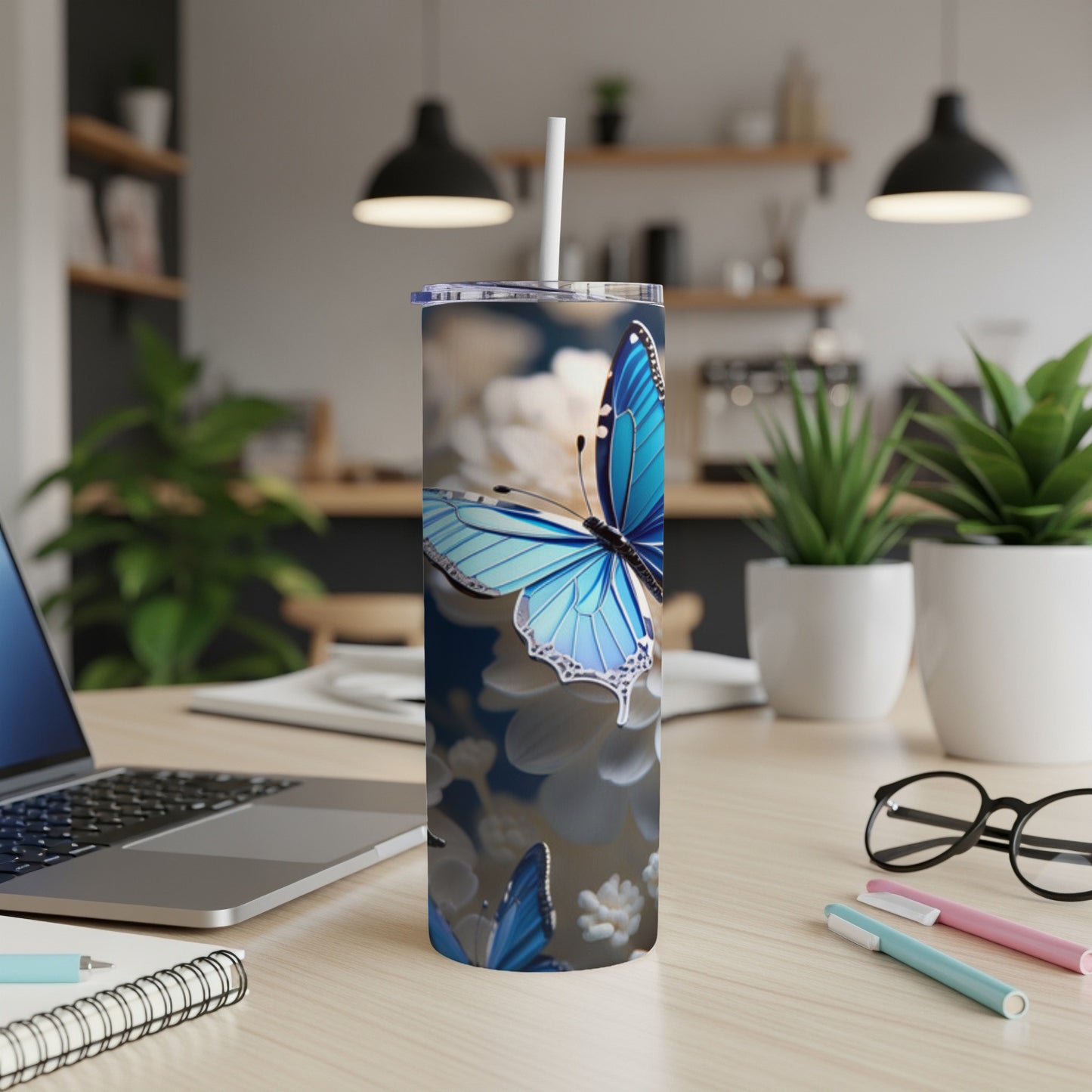 Blue butterfly design on a white stainless steel tumbler with straw.