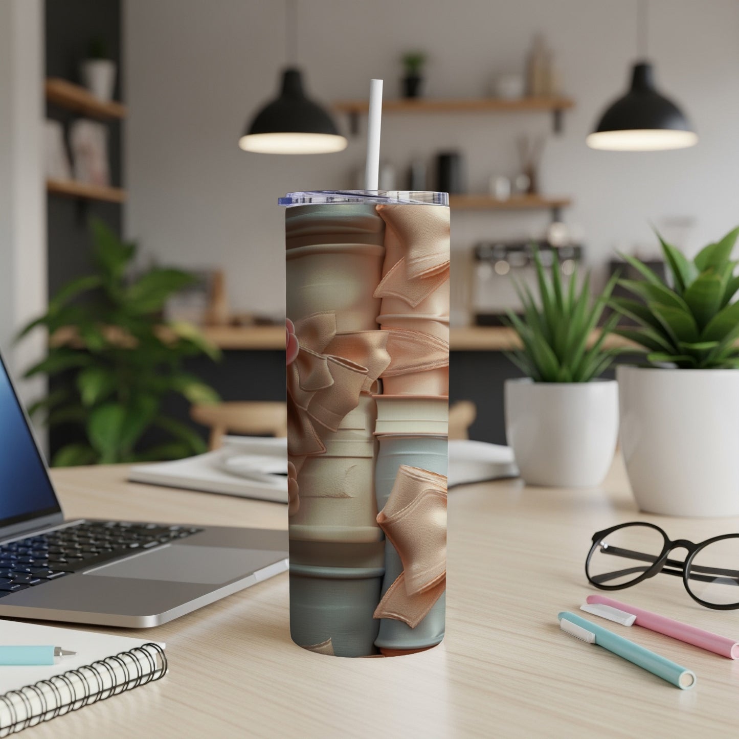 Tall tumbler with stacked gift boxes and bows on a desk.