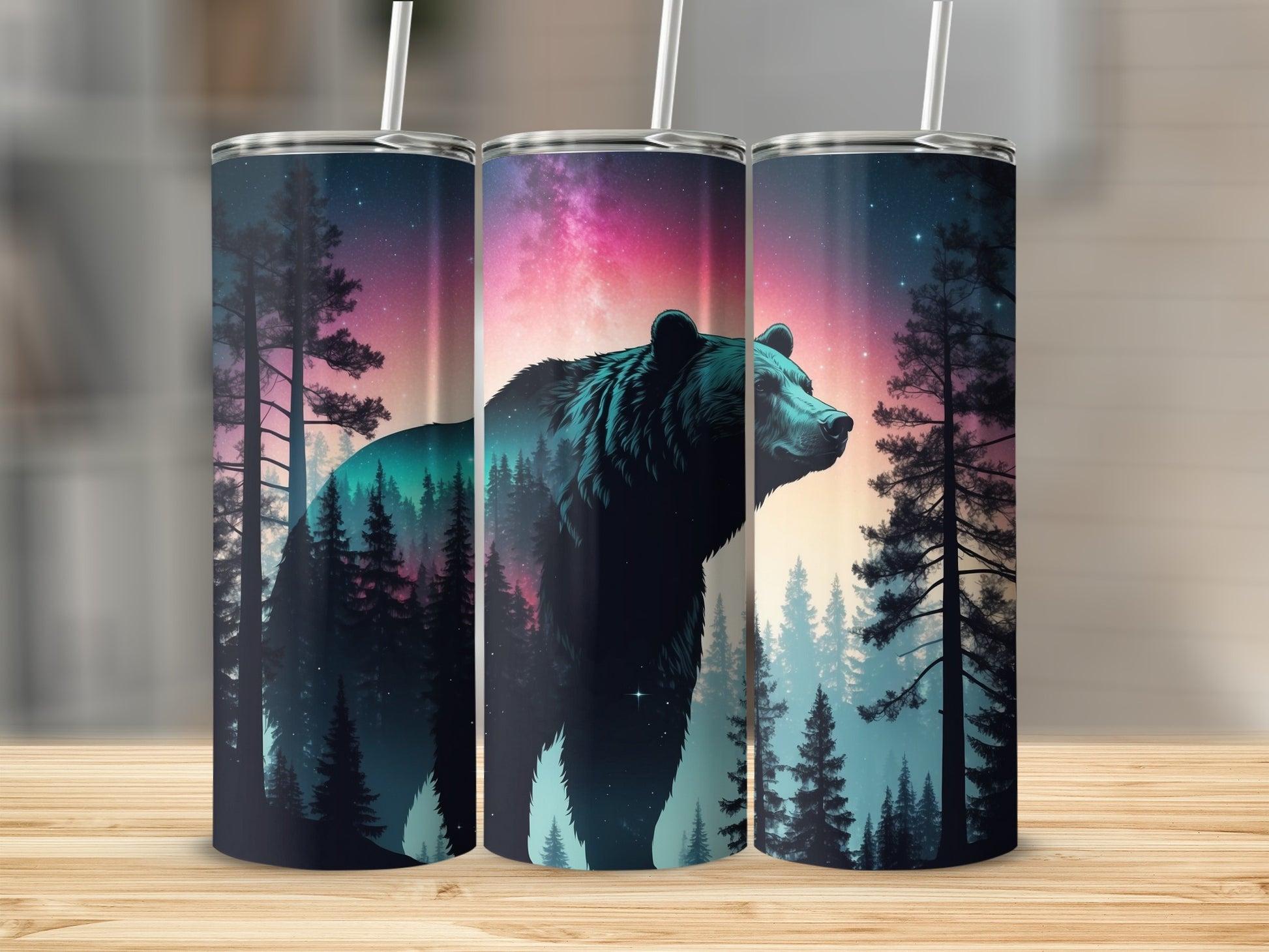 Bear silhouette against a cosmic forest sky on three tumblers.