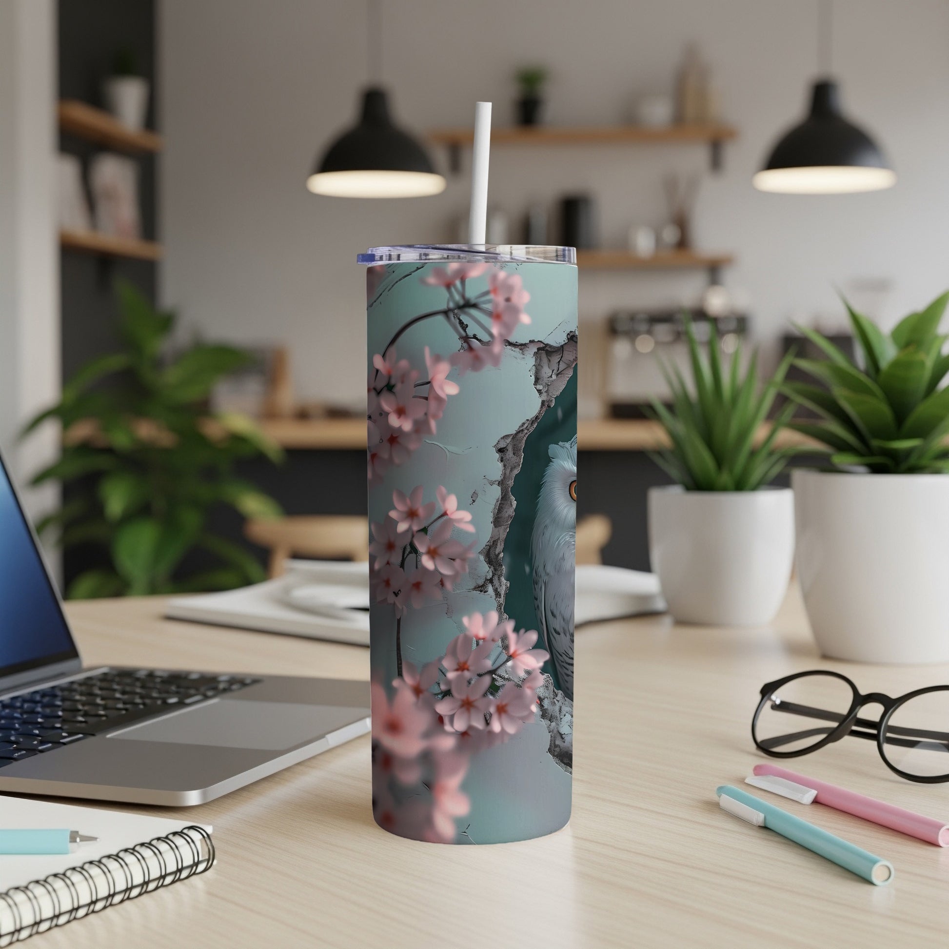 White owl with pink blossoms on a blue and grey tumbler with a straw.
