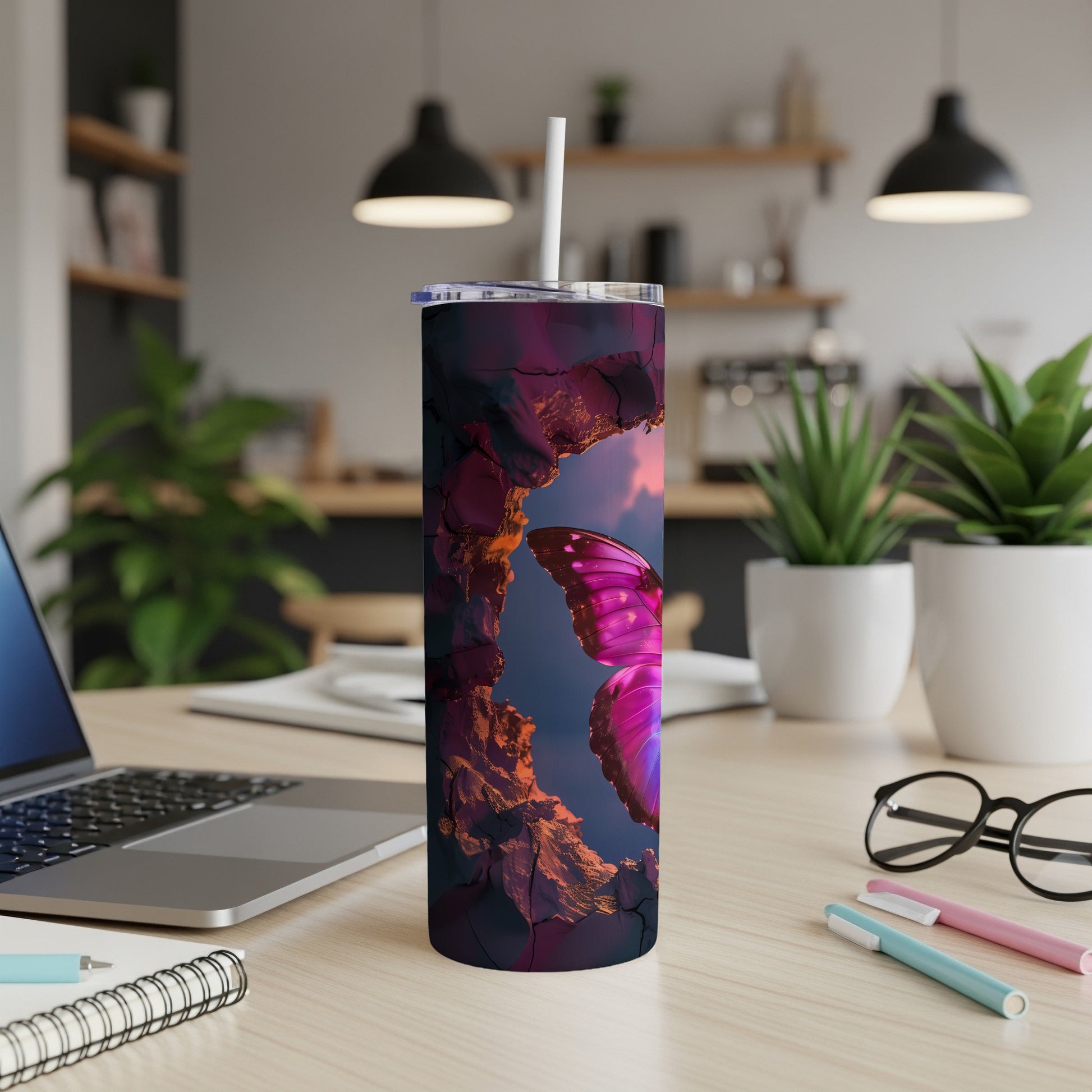 Tumbler with a vibrant butterfly on a rocky landscape at sunset.