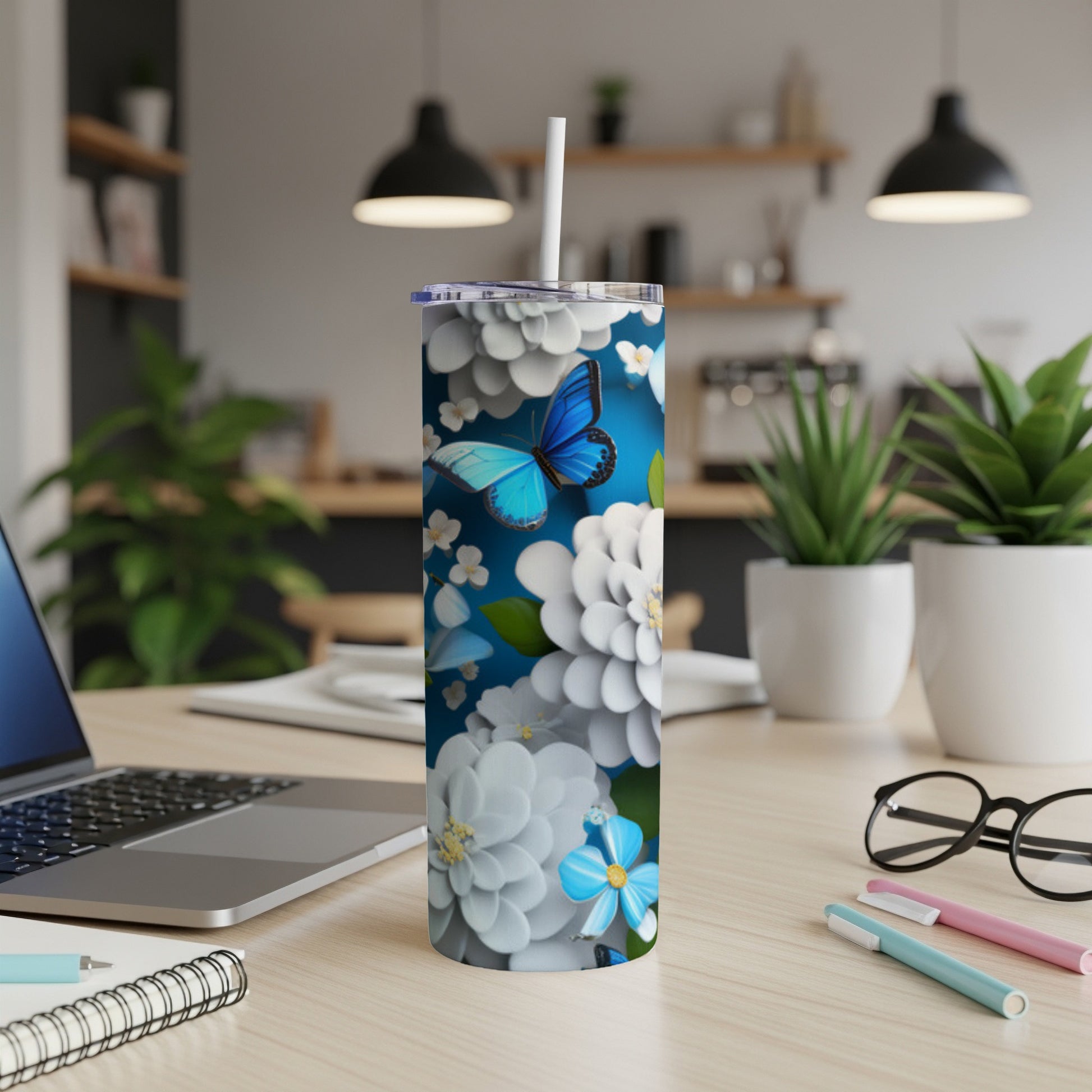 Blue butterfly on white floral patterned tumbler with straw.