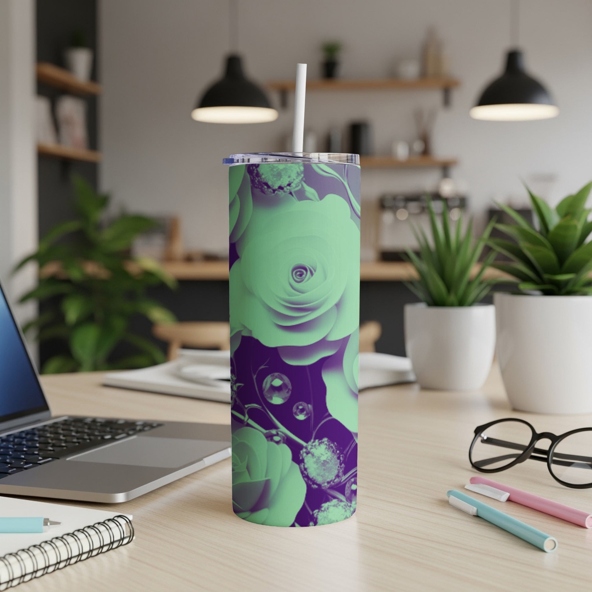 Purple and mint green floral tumbler with straw on a desk.