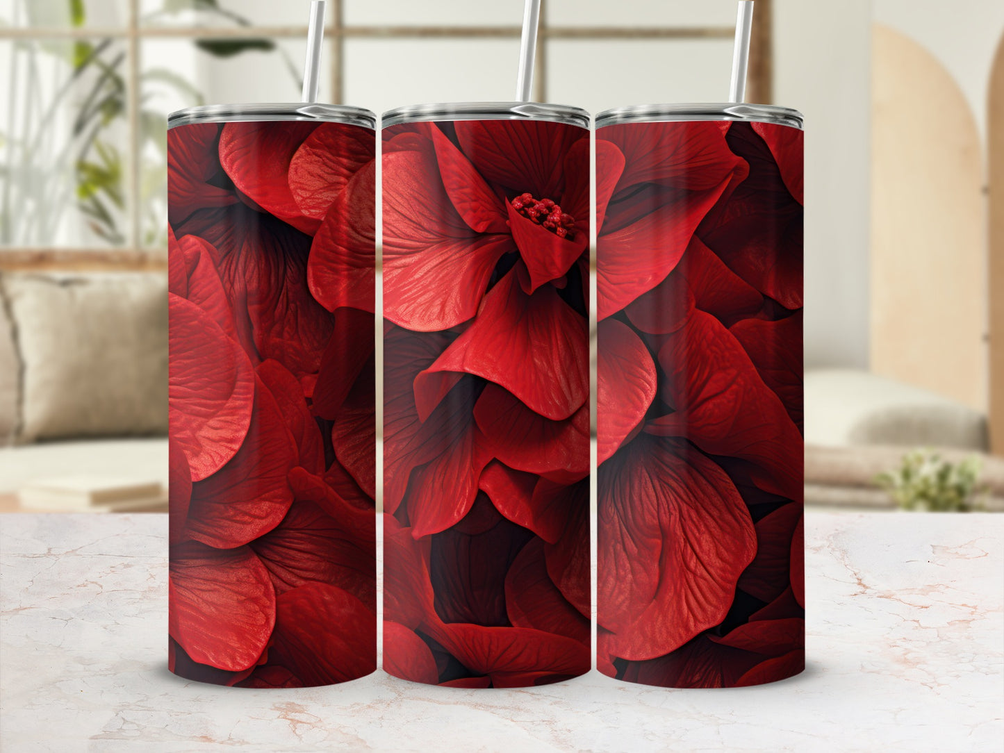 Three red floral pattern tumblers with straws displayed on a marble surface.