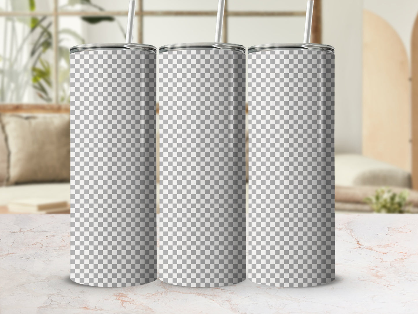 Three blank checkered tumblers with straws on a marble surface.