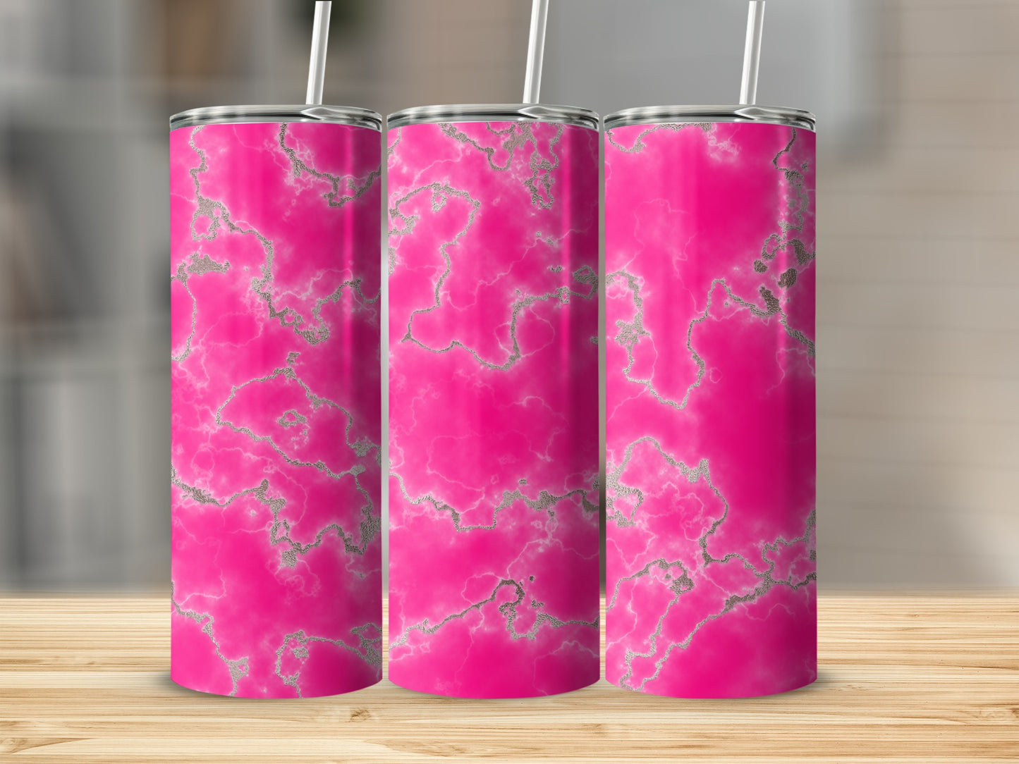 Three pink marble tumblers with silver veining on a wooden surface.