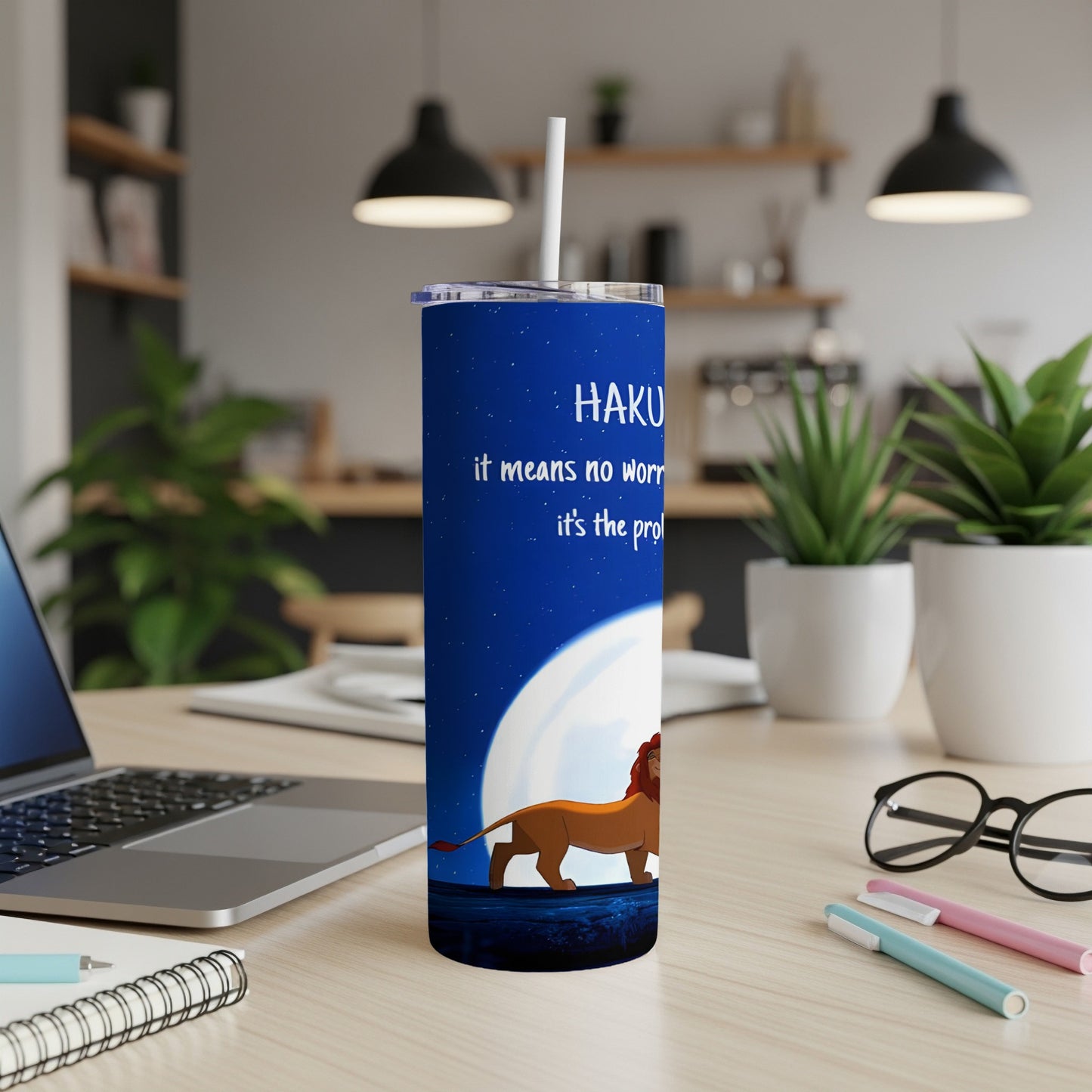 Lion King tumbler with "Hakuna Matata" quote on a desk.
