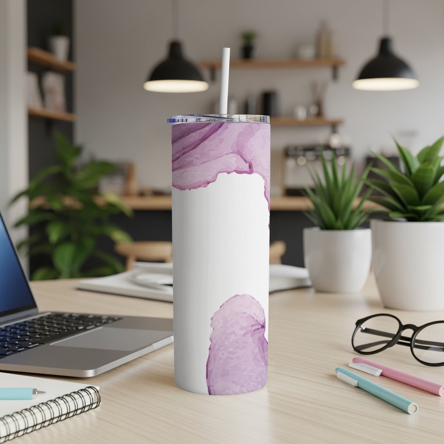 White tumbler with a purple watercolor splash design, on a desk.
