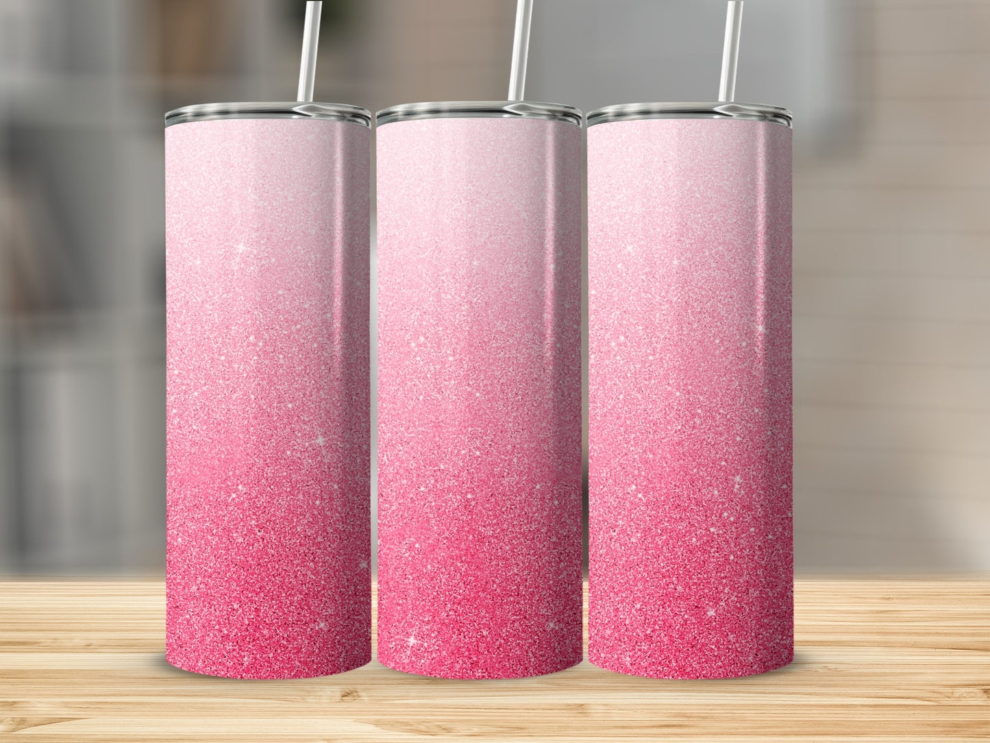 Three tall tumblers with pink glitter gradient and white straws.