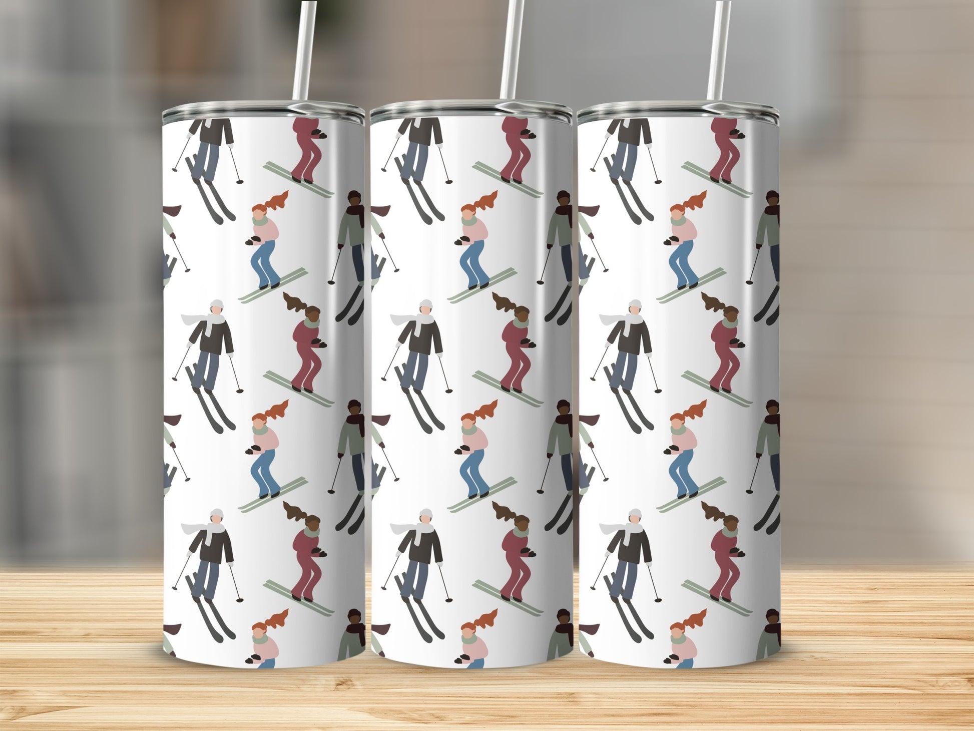 Three tumblers with a repeating ski pattern on a wooden surface.