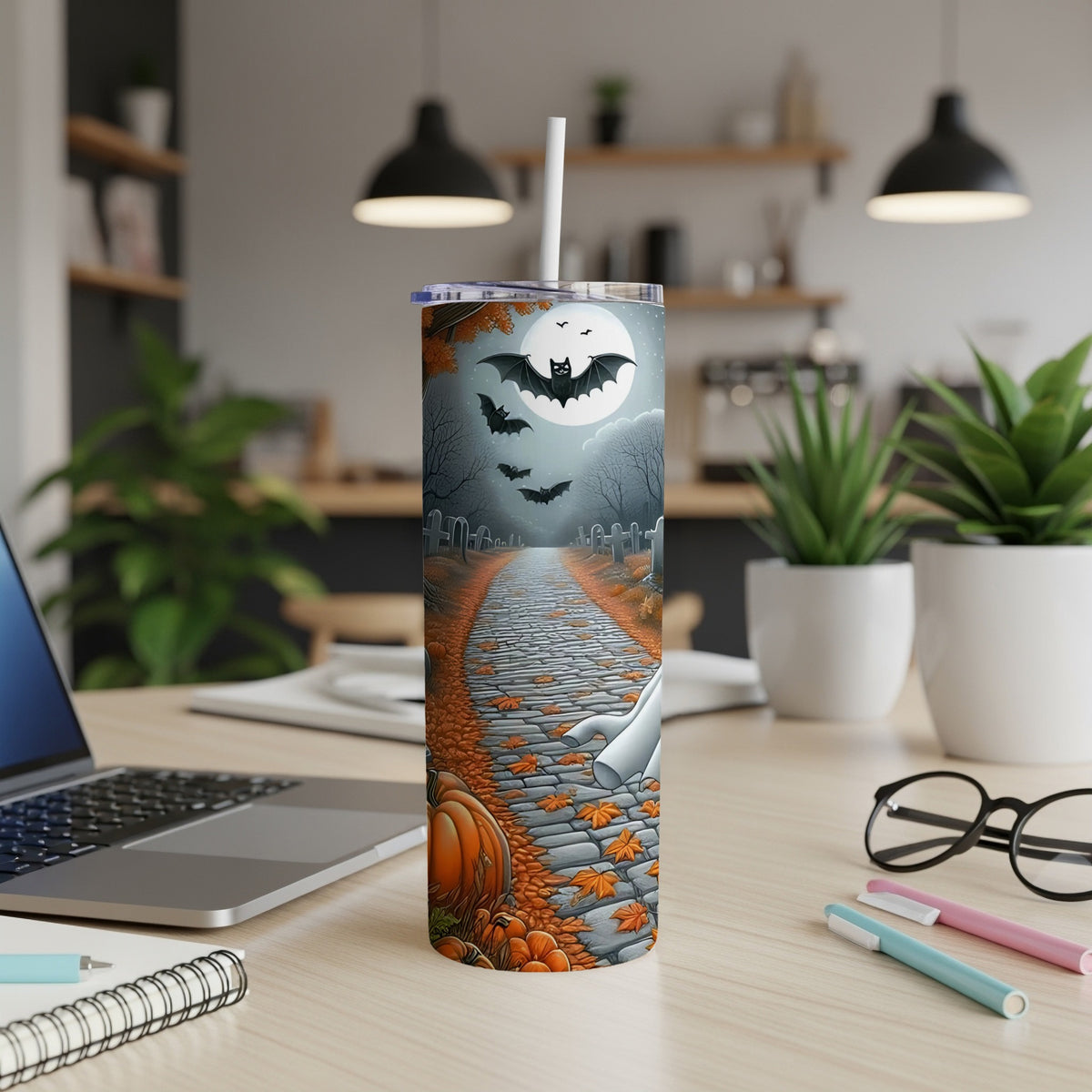 Tumbler with Halloween cemetery scene: bats, moon, ghost, pumpkin, and fallen leaves.