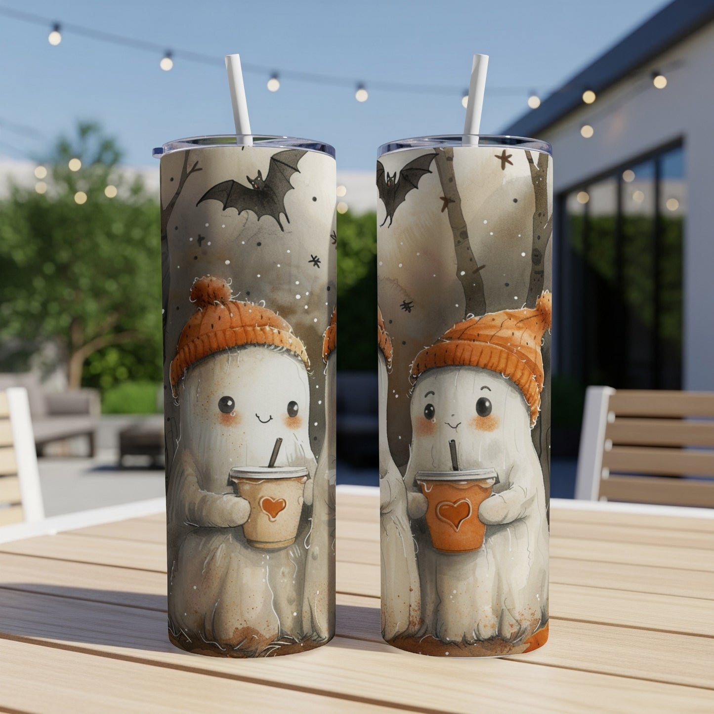 Two tumblers with cute ghosts wearing orange hats holding coffee cups, set outdoors.