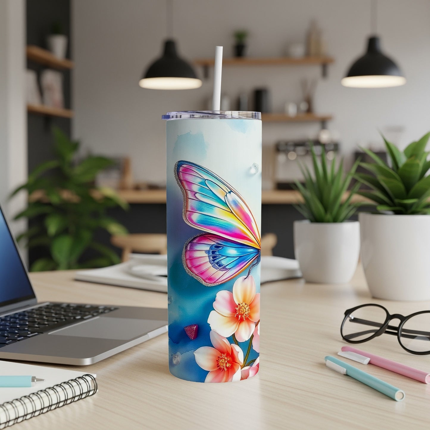 Tumbler with butterfly wing and flower design, straw inserted.