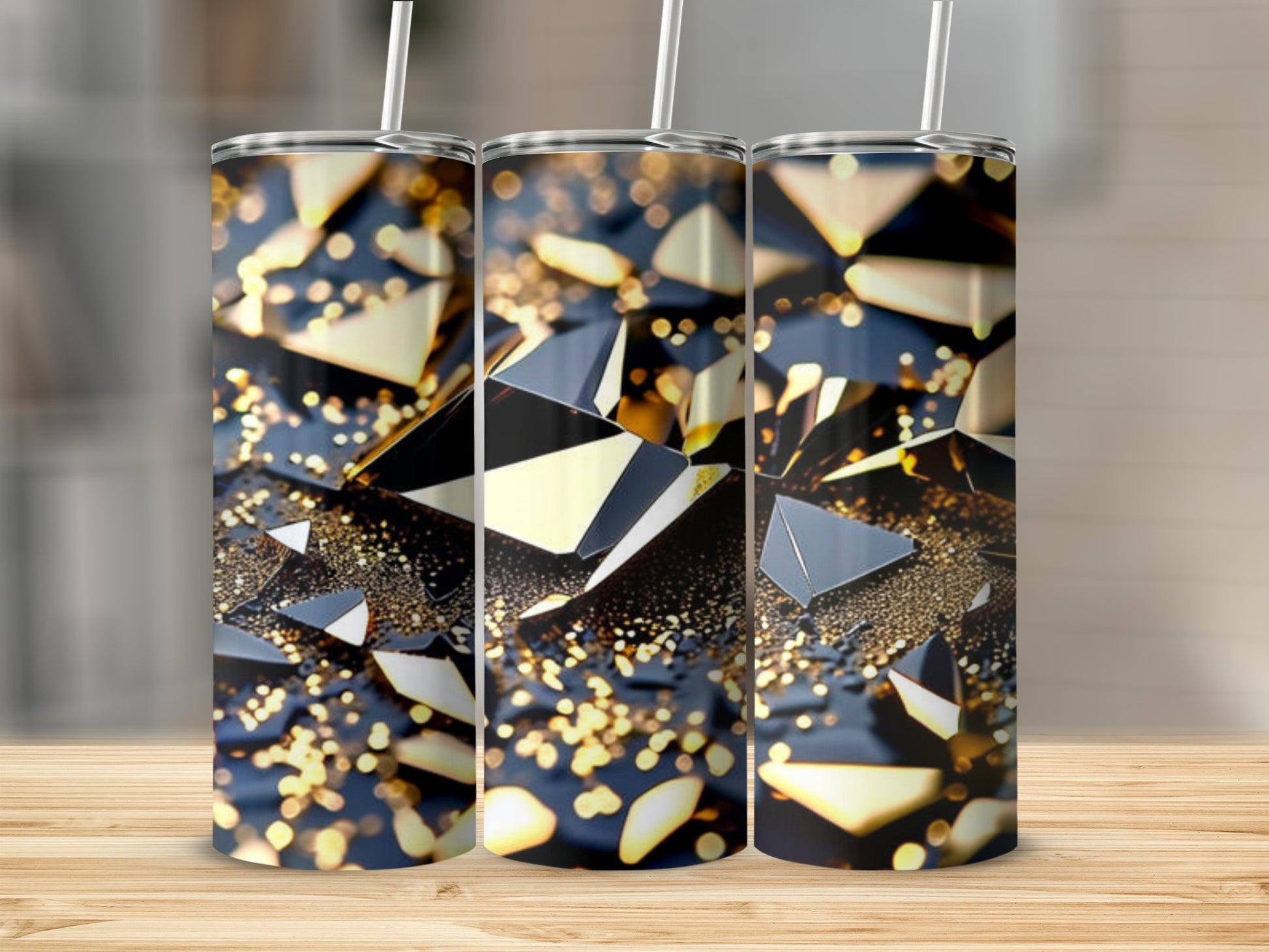 Three tumblers with abstract geometric gold and black design and bokeh lights.