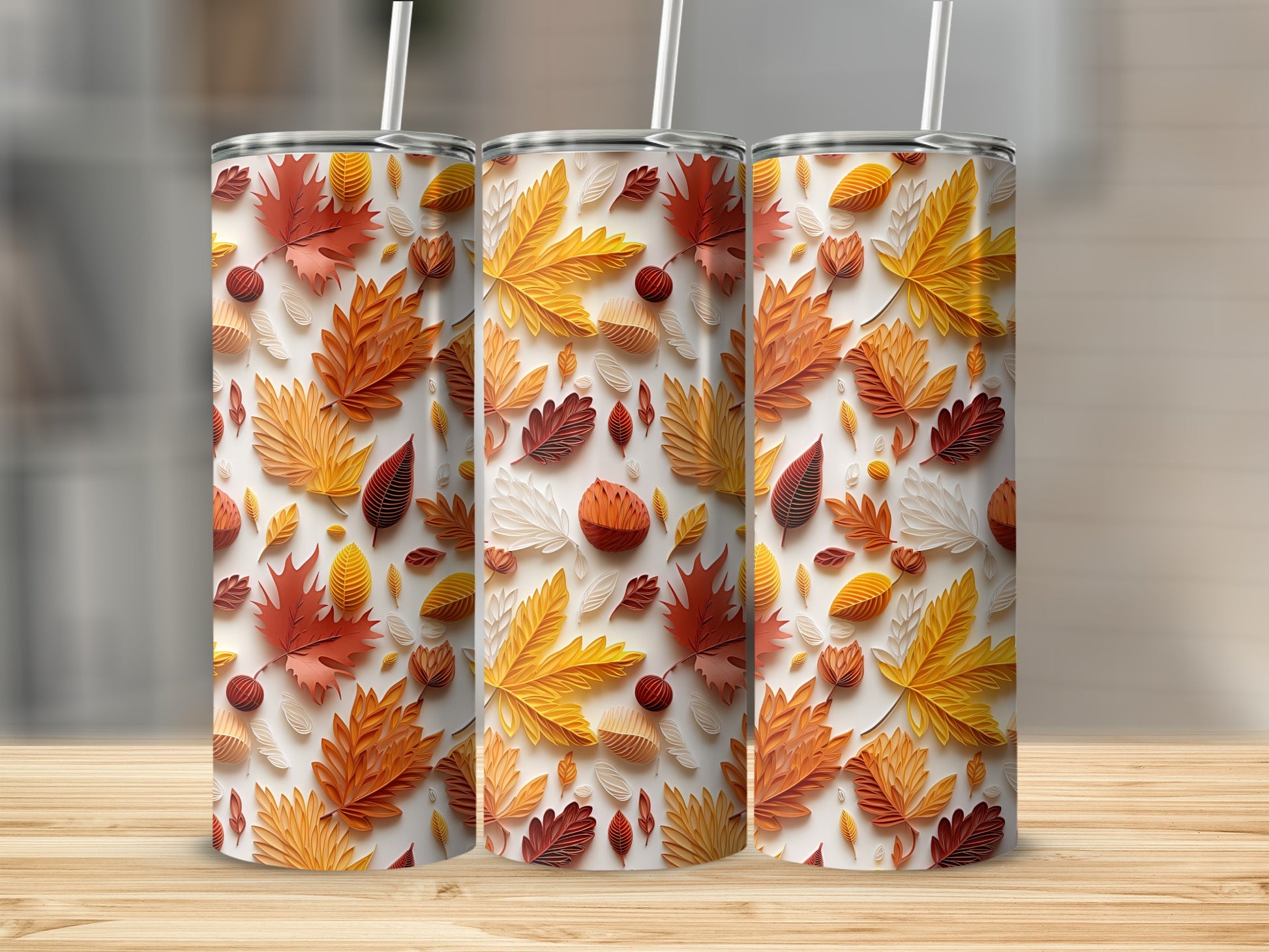 Three tumblers with an autumn leaf pattern in orange, red, and beige.
