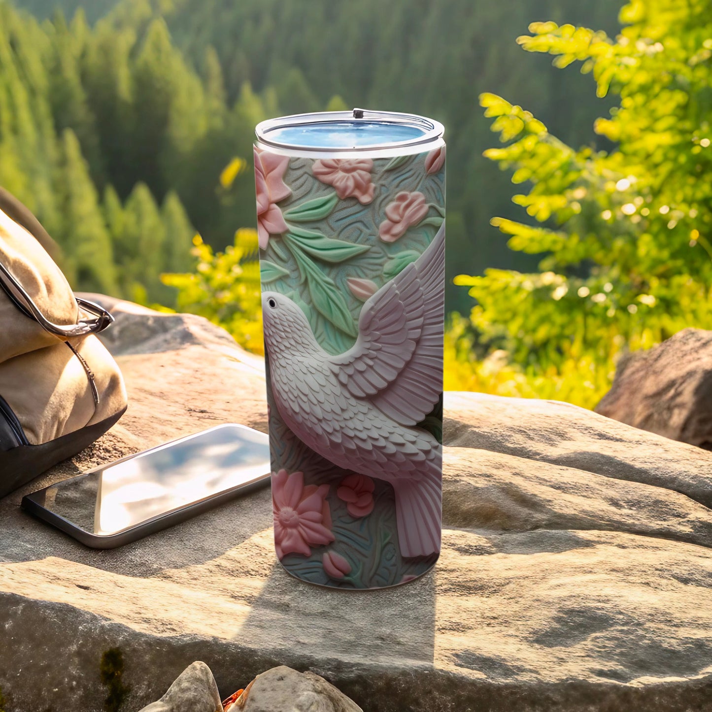 White dove with pink flowers on a textured tumbler, outdoors.