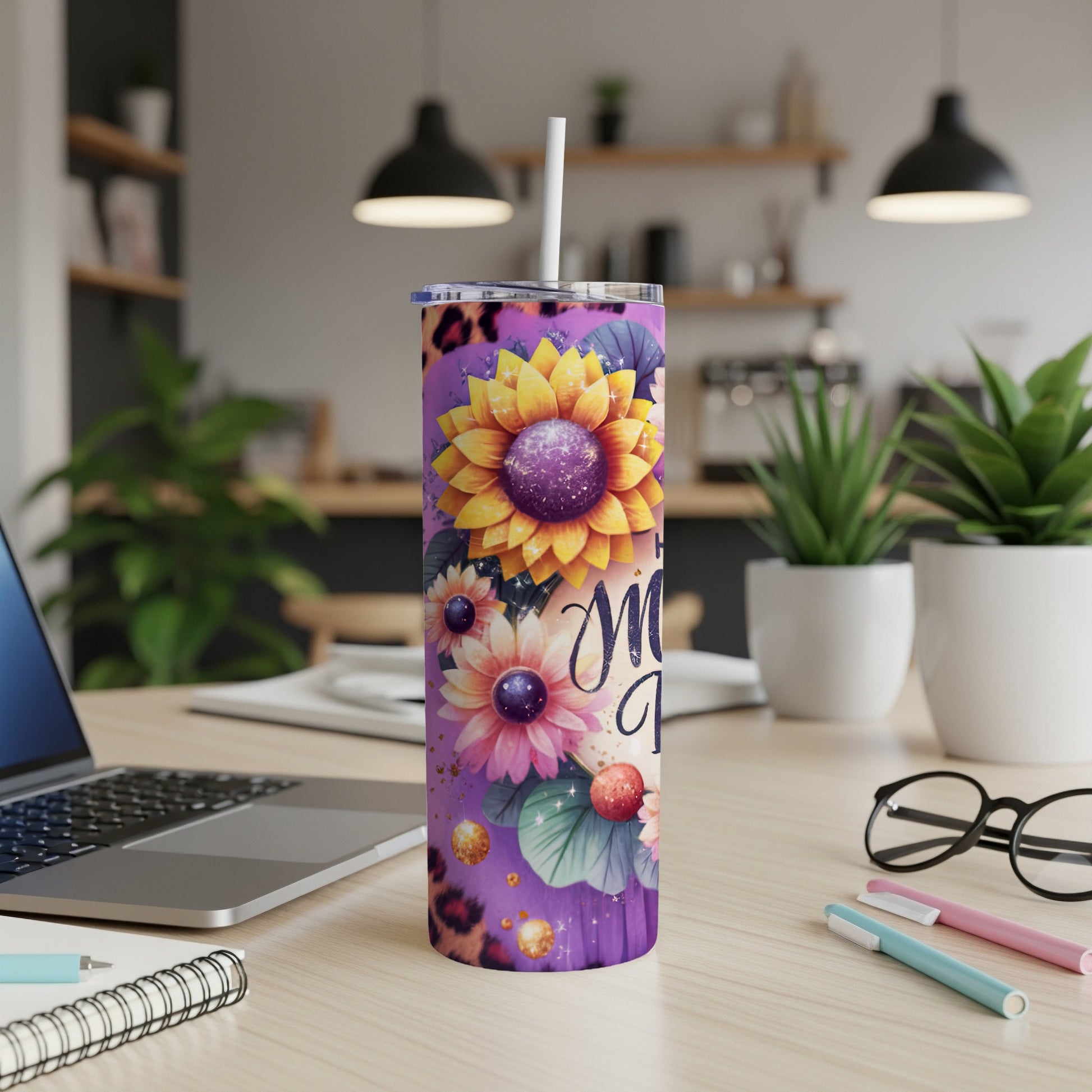 Floral tumbler with "Mom" text and straw, on a desk.