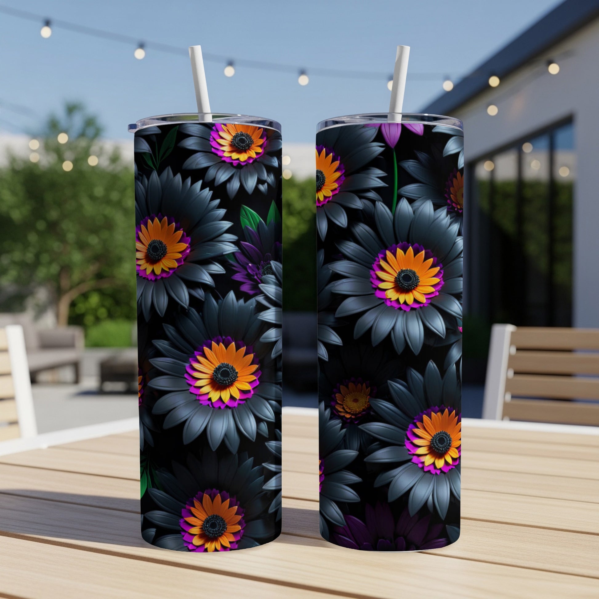 Two tumblers with black and orange floral pattern on outdoor table.