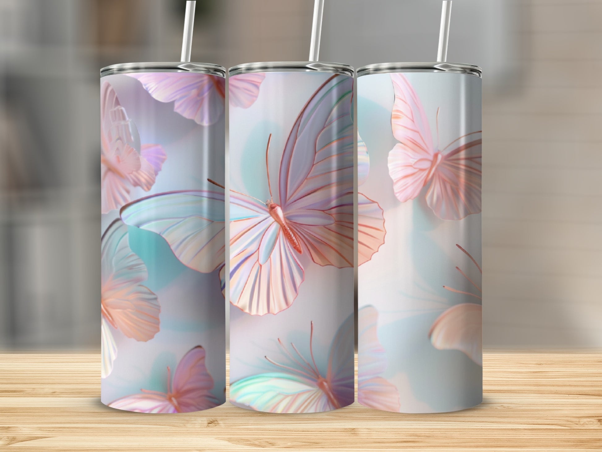 Three tumblers with iridescent butterfly design on a wooden surface.