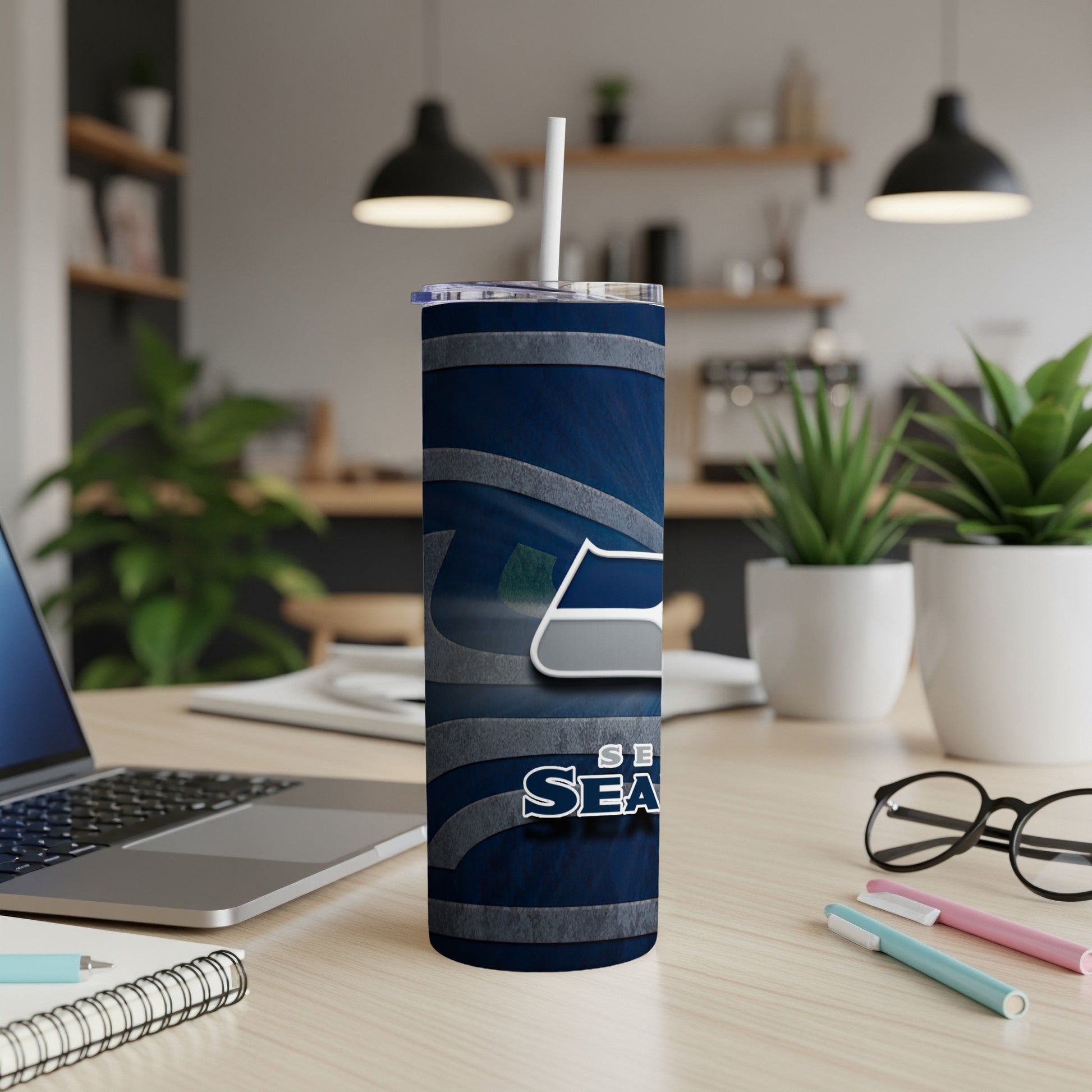 Seattle Seahawks tumbler with straw on a desk.