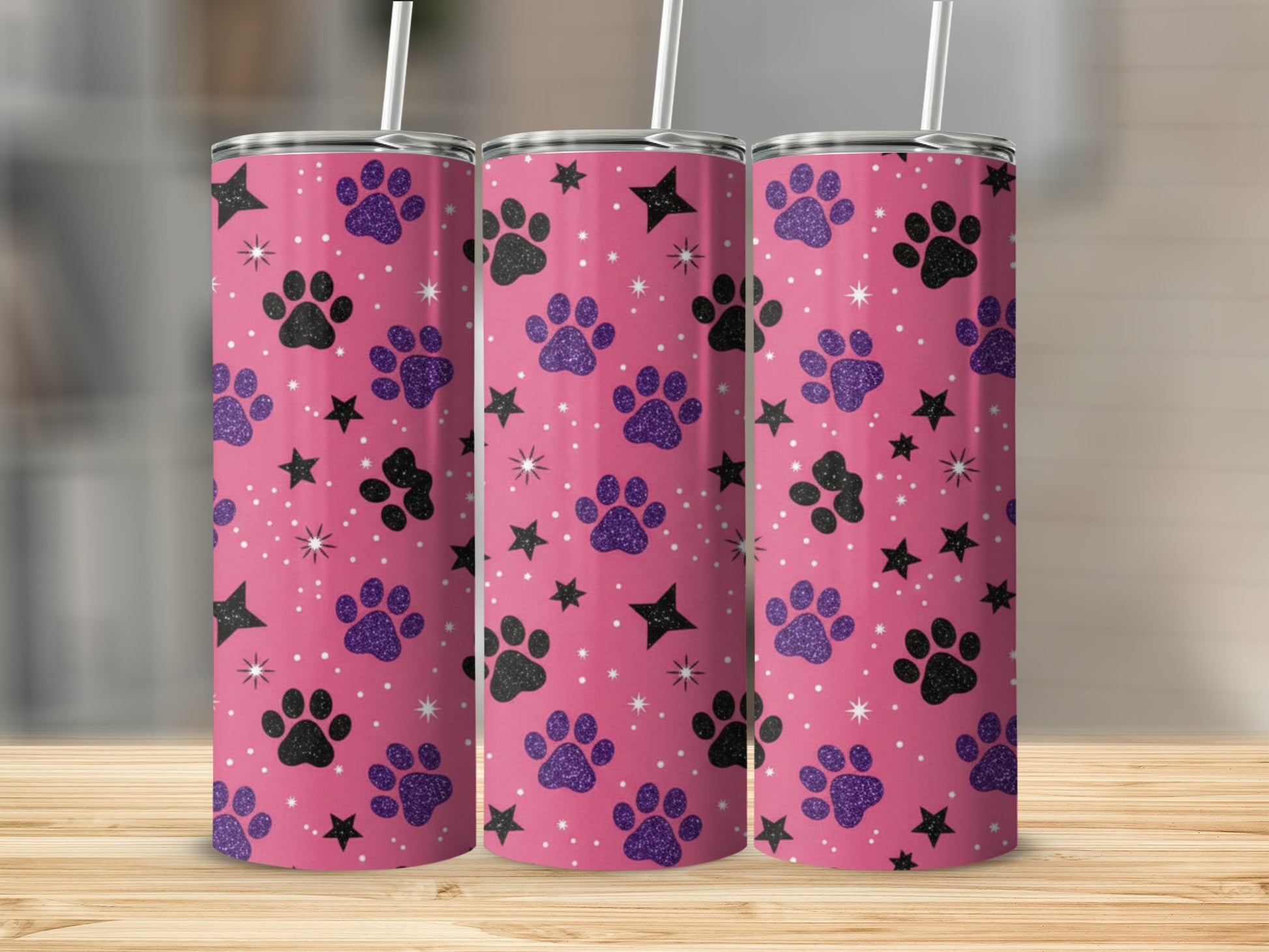 Pink tumbler with purple paw prints and black stars pattern.