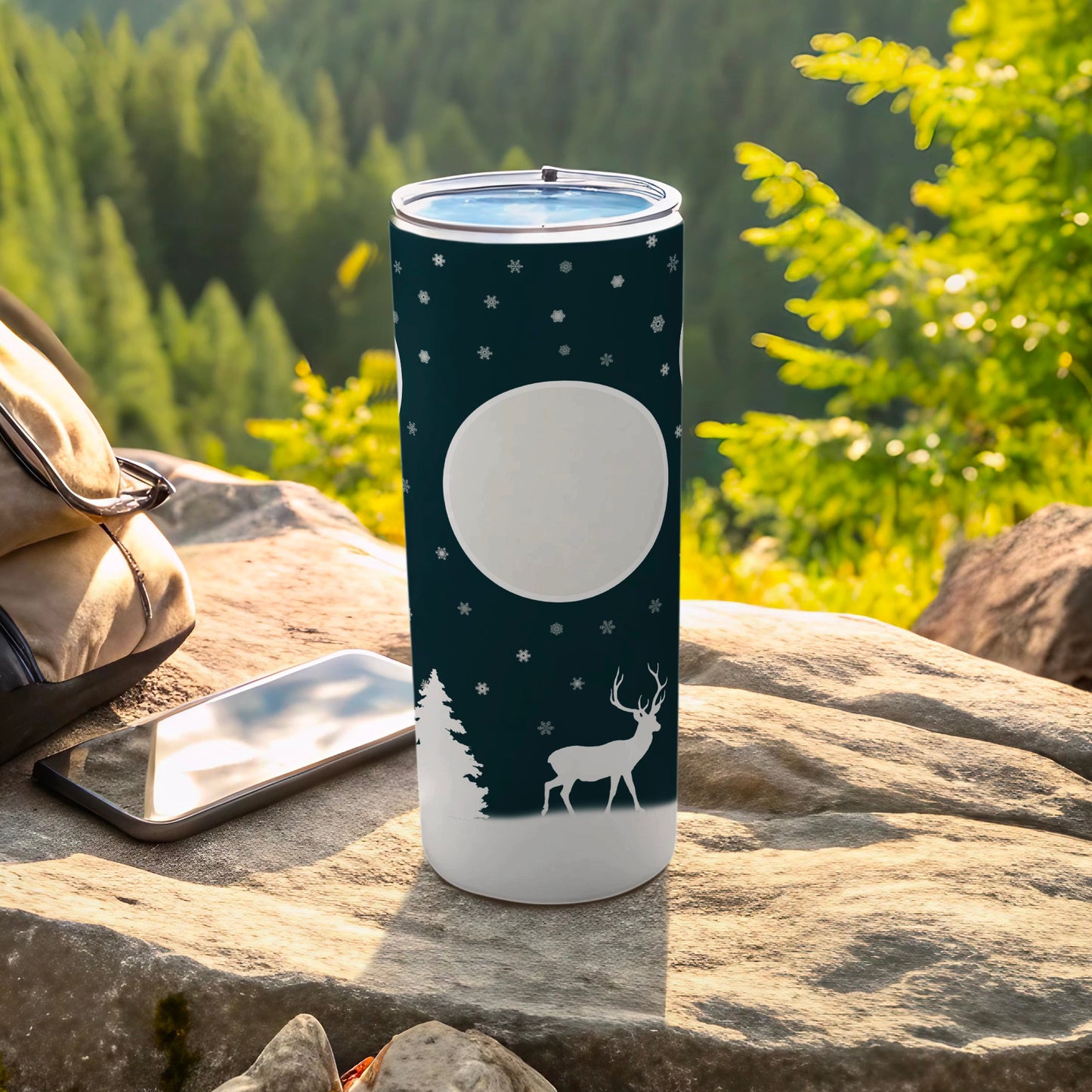 White tumbler with deer and snowflake design on nature background.