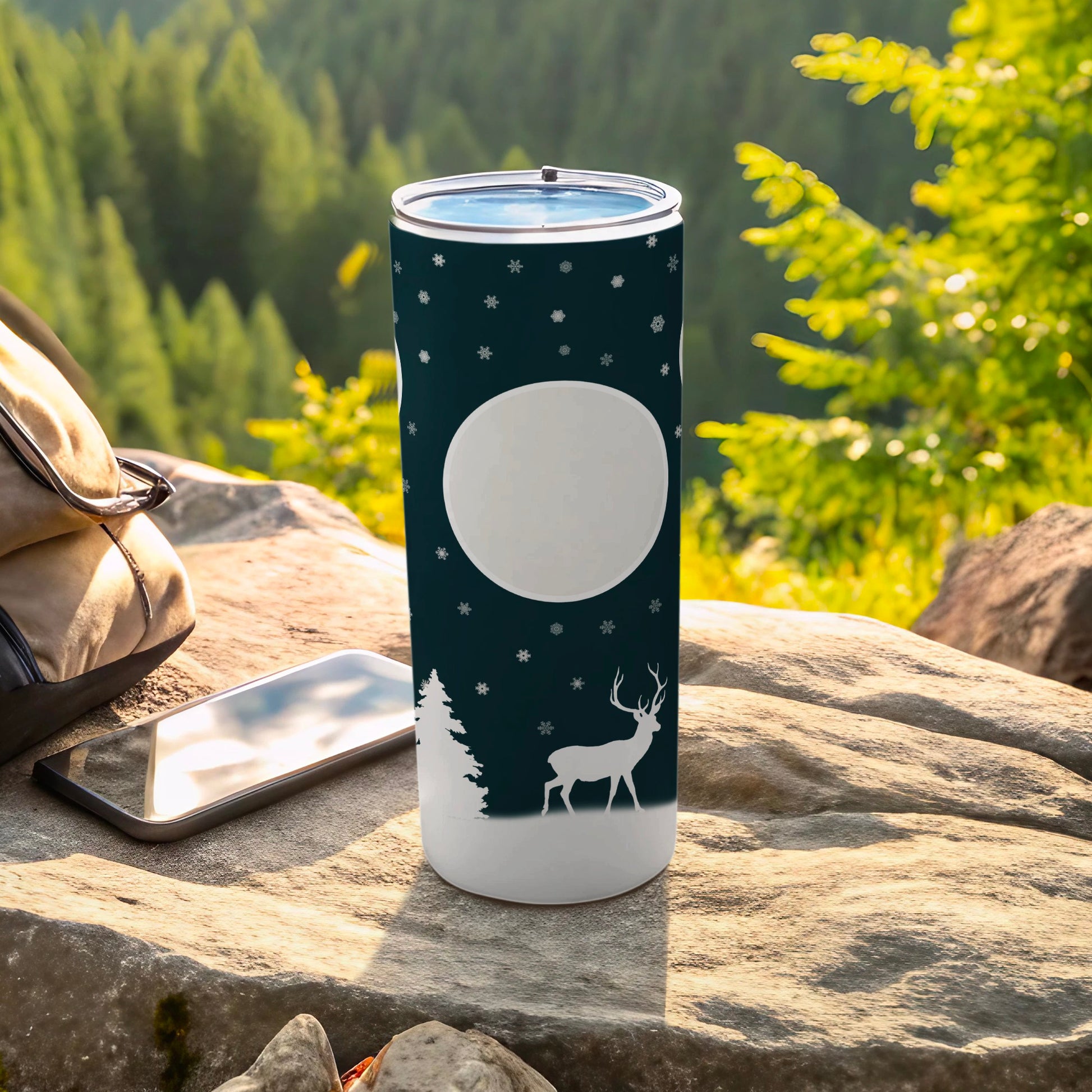 White tumbler with deer and snowflake design on nature background.