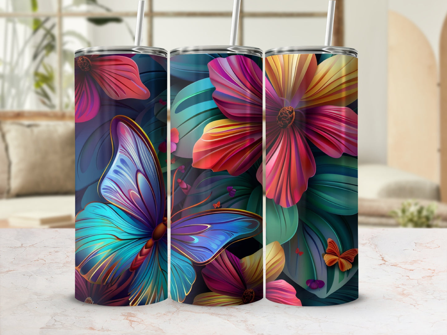 Three colorful floral tumblers with butterfly designs on a marble surface.